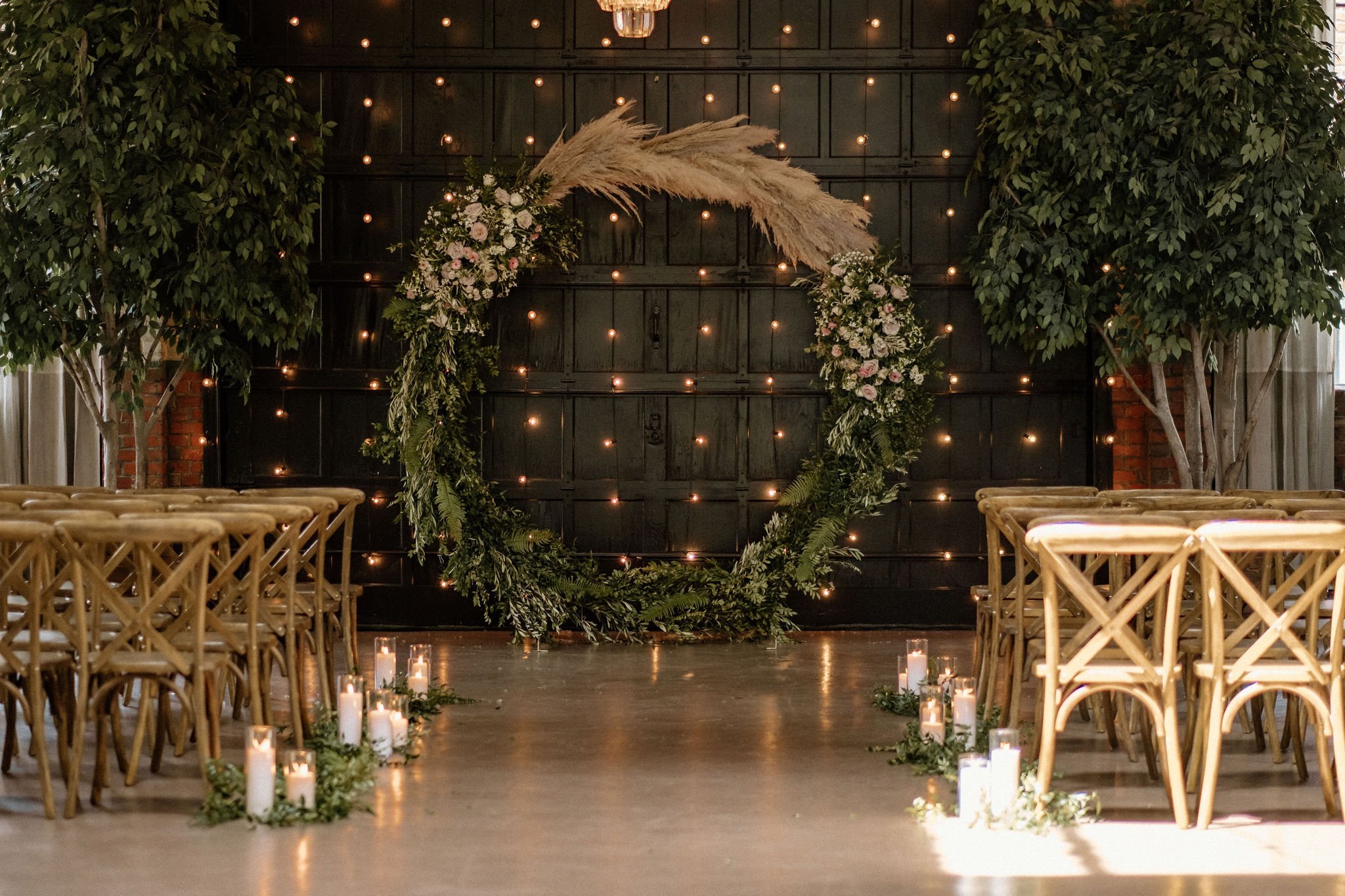 round wedding ceremony arch with greenery, pampas grass, and florals