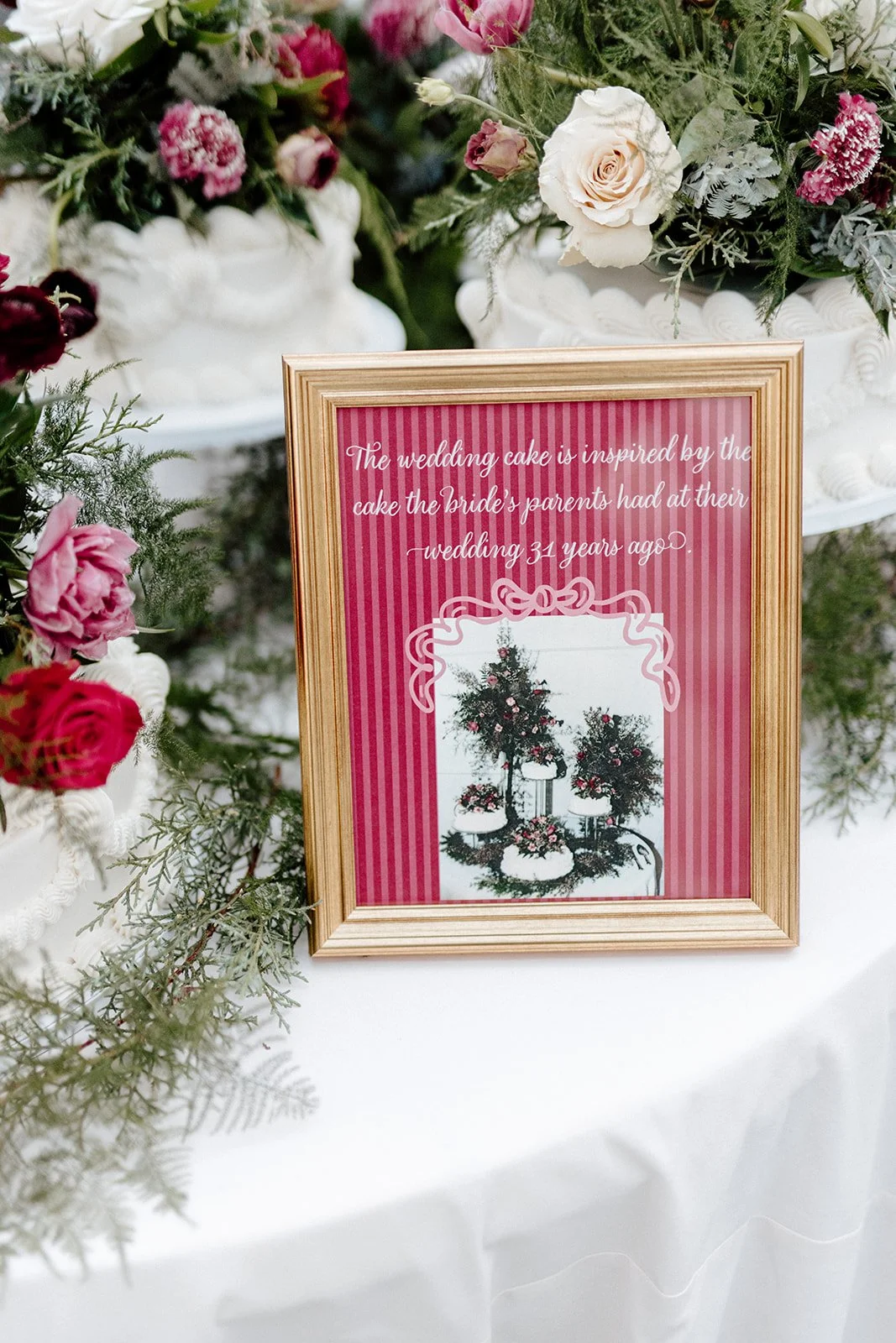 ivory-and-beau-savannah-georgia-wedding-dresses-southern-weddings-mackey-house-pink-florals-luxury-wedding-florals-reception-tablescape-red-pink-winter-wedding-christmas-cake-sign.jpg