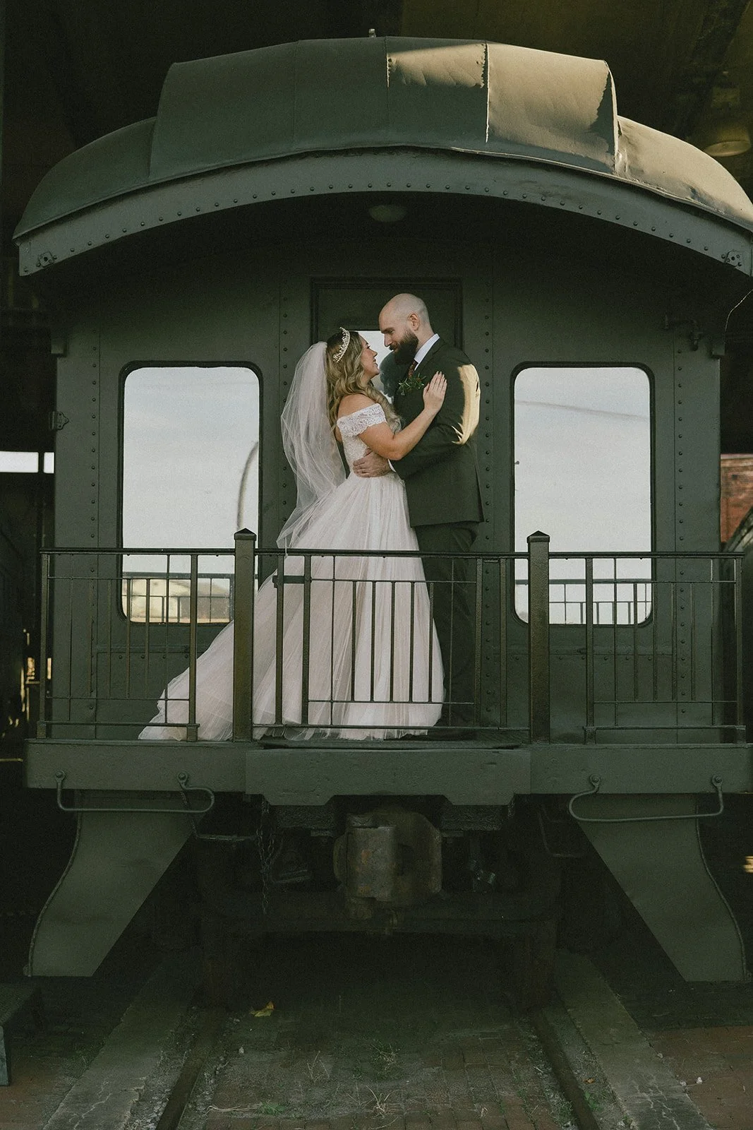 Bride and groom portrait on historic train platform at Georgia State Railroad Museum wedding venue in Savannah Georgia industrial Southern destination wedding.