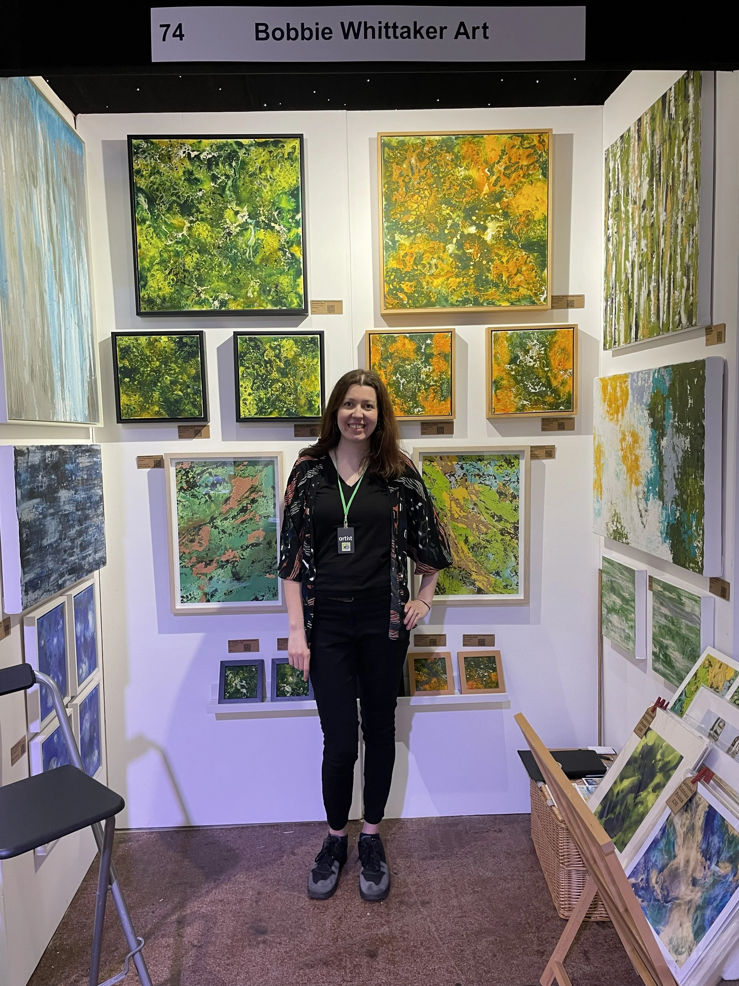 Abstract artist Bobbie Whittaker at Bath Art Fair showcasing her green and orange highly textured abstract oil paintings from her Geothermal Series