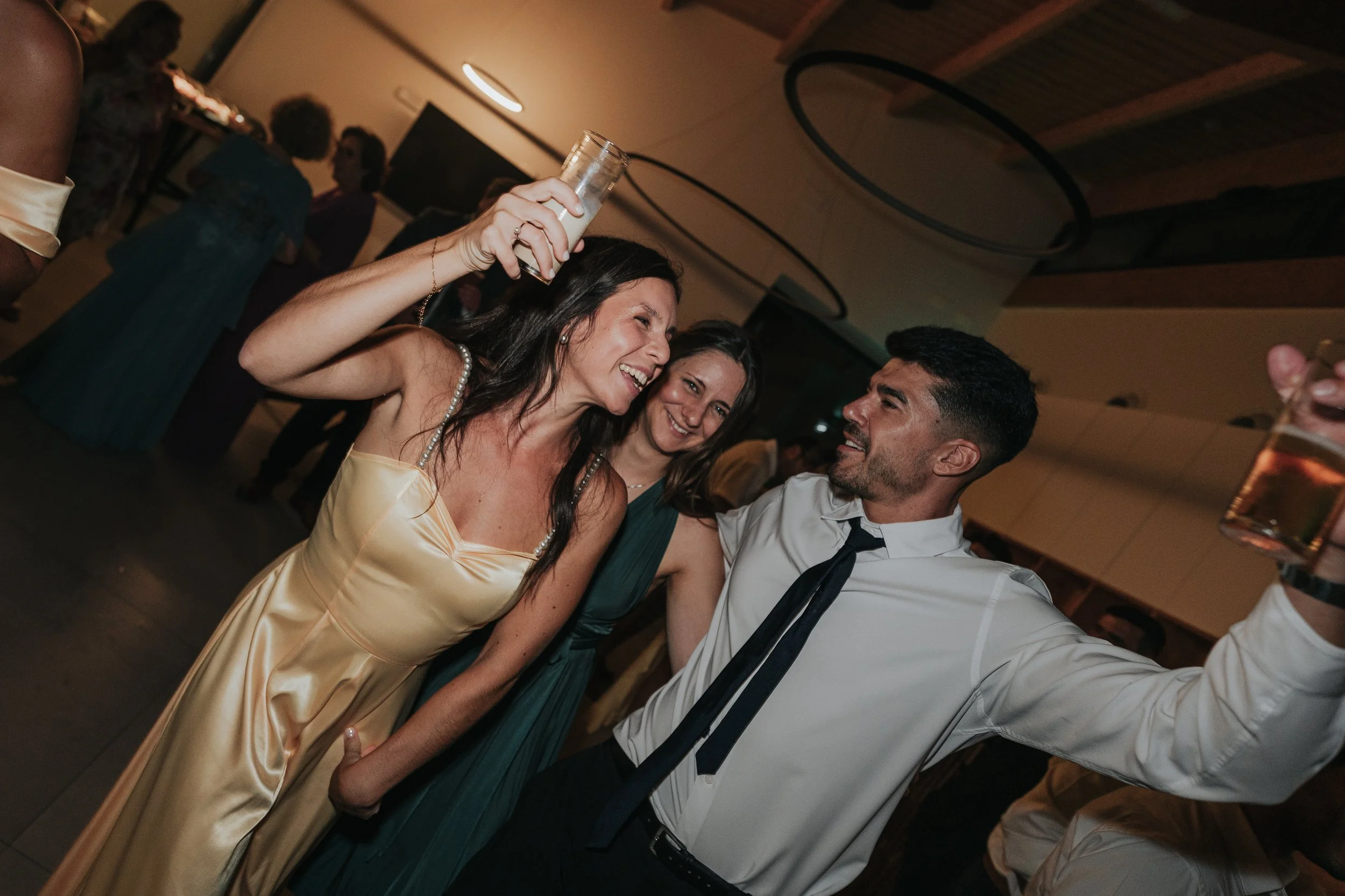 People dancing and socializing at a party or celebration in an indoor venue.