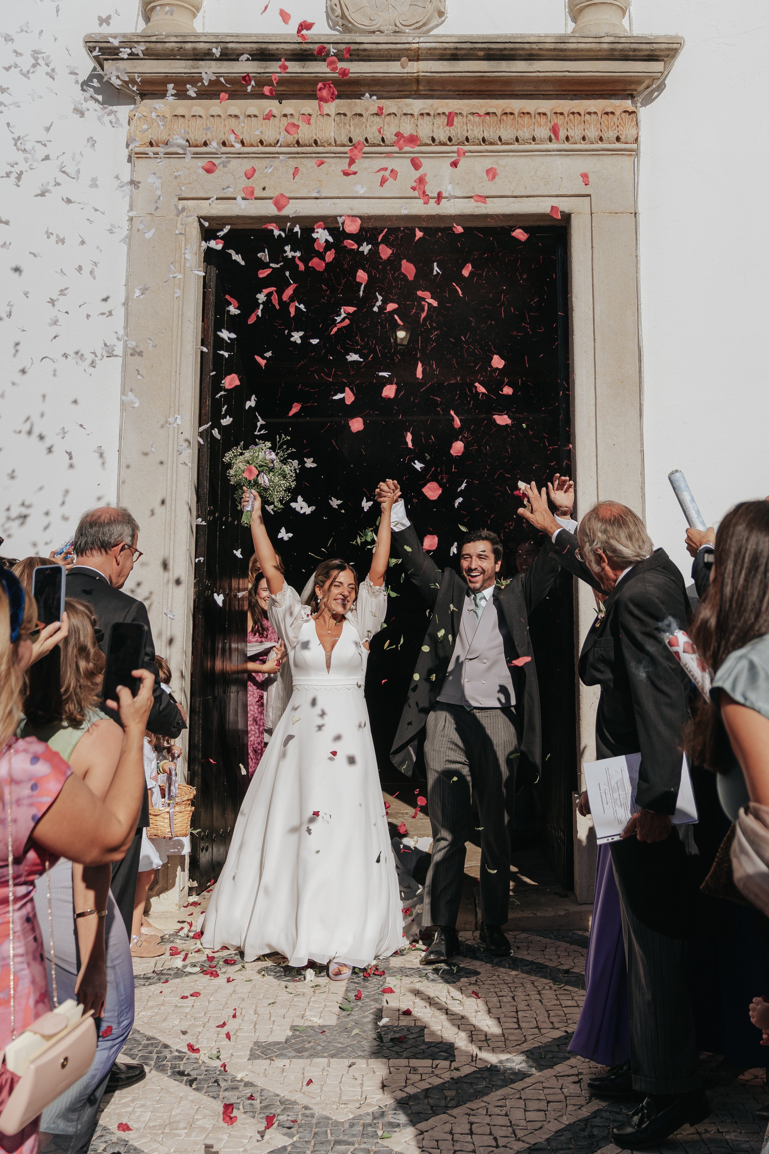 Bride and groom leaving the church with flower petals