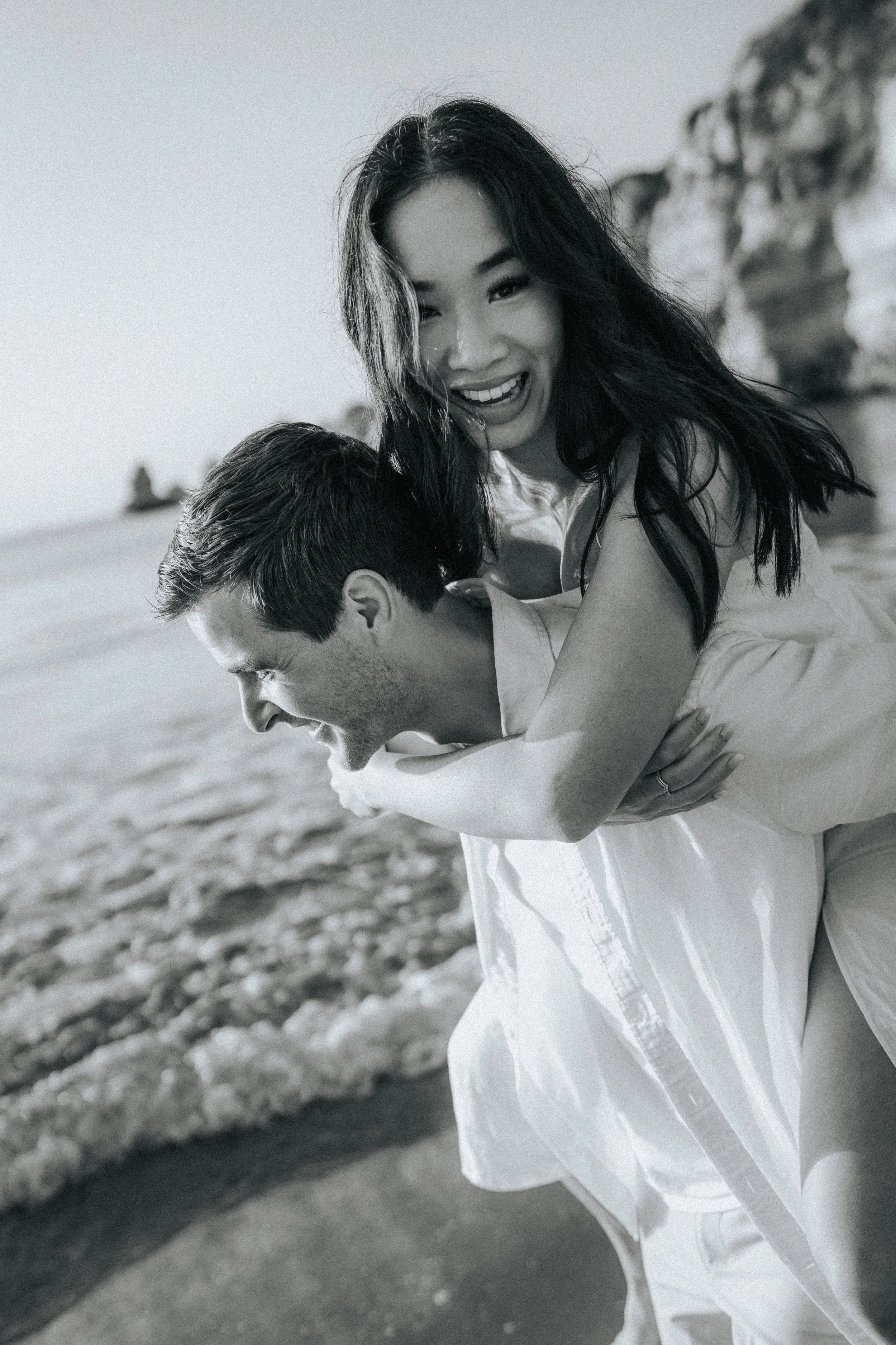 Bride riding on groom’s shoulders at Praia Dona Ana