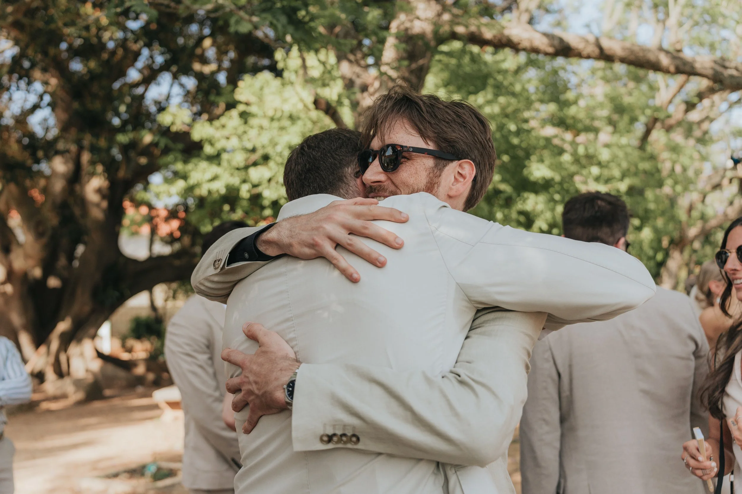 Emotional moment of the groom hugging a friend during the wedding in Portugal