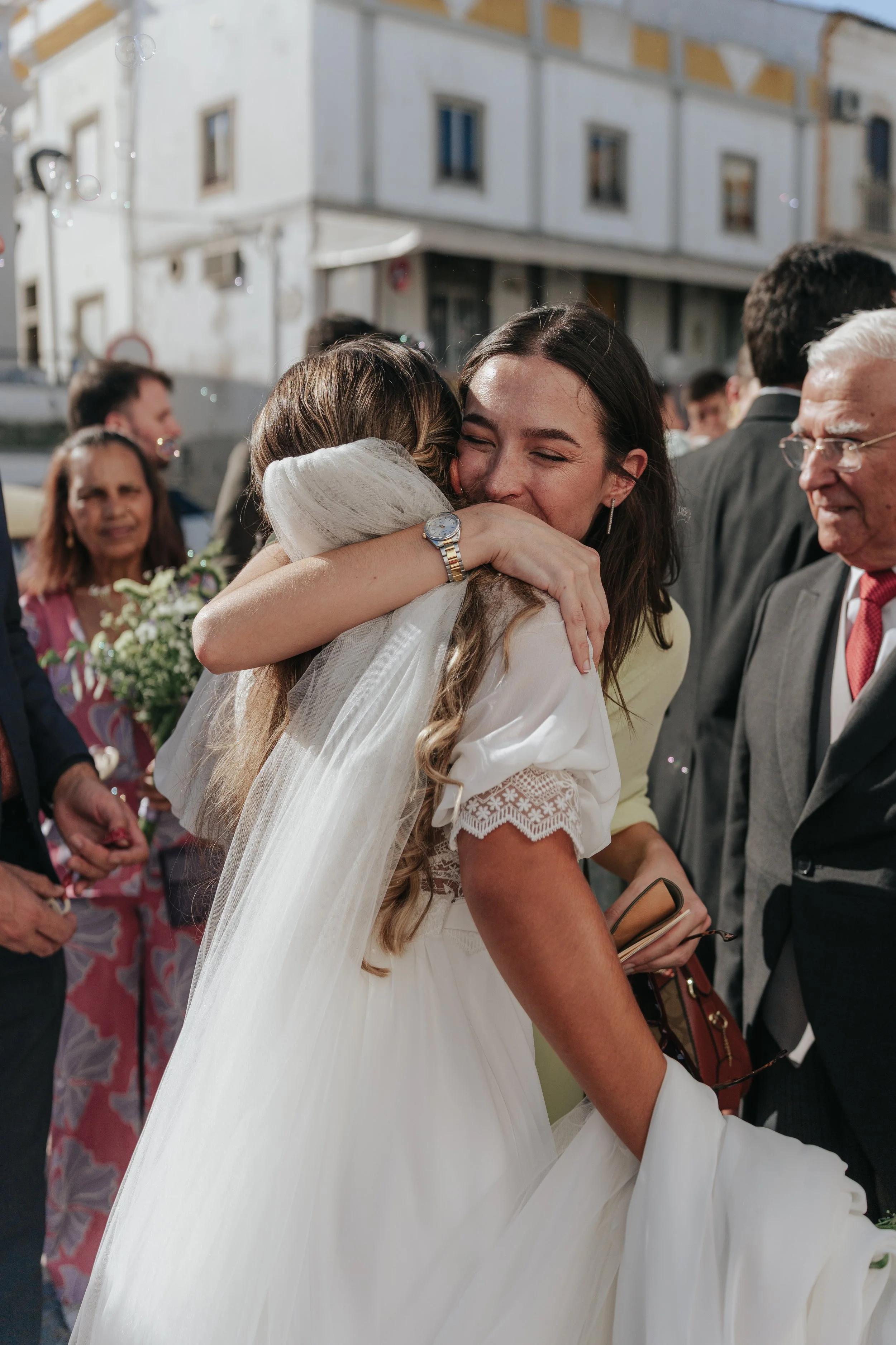 Emotional moment of a friend hugging the bride after the ceremony in Portugal