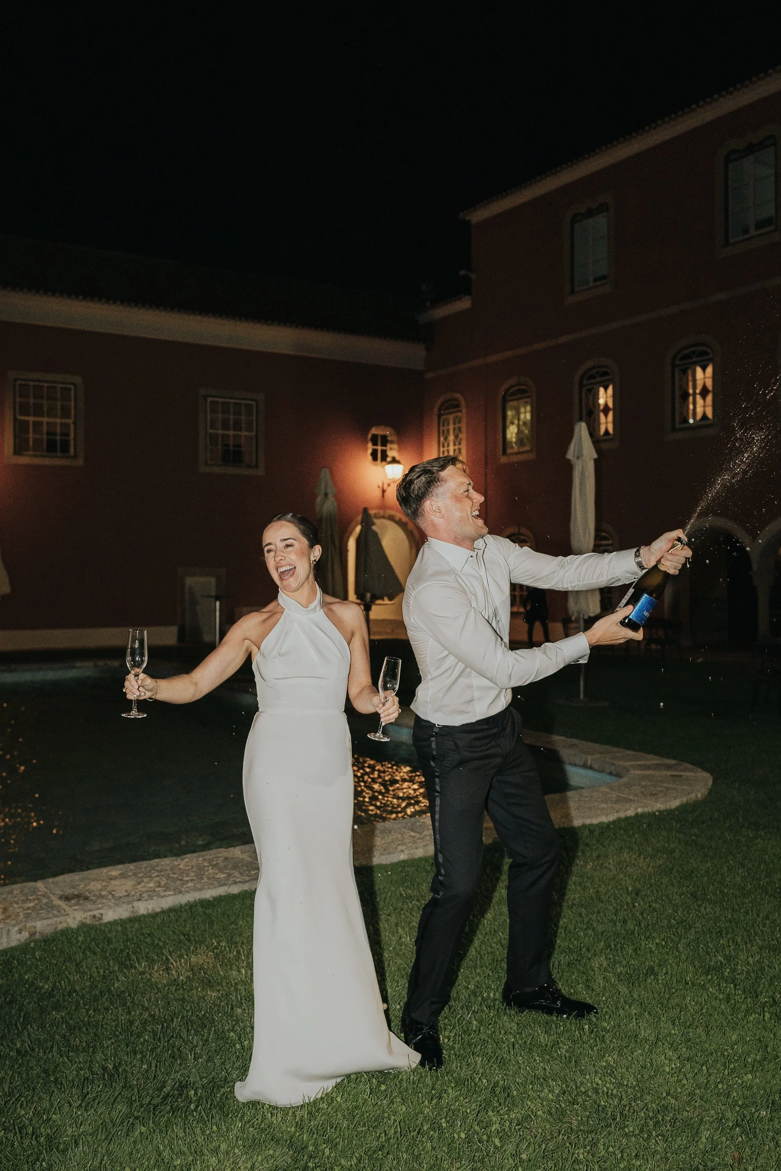 Bride and groom opening champagne at Penha Longa in Sintra