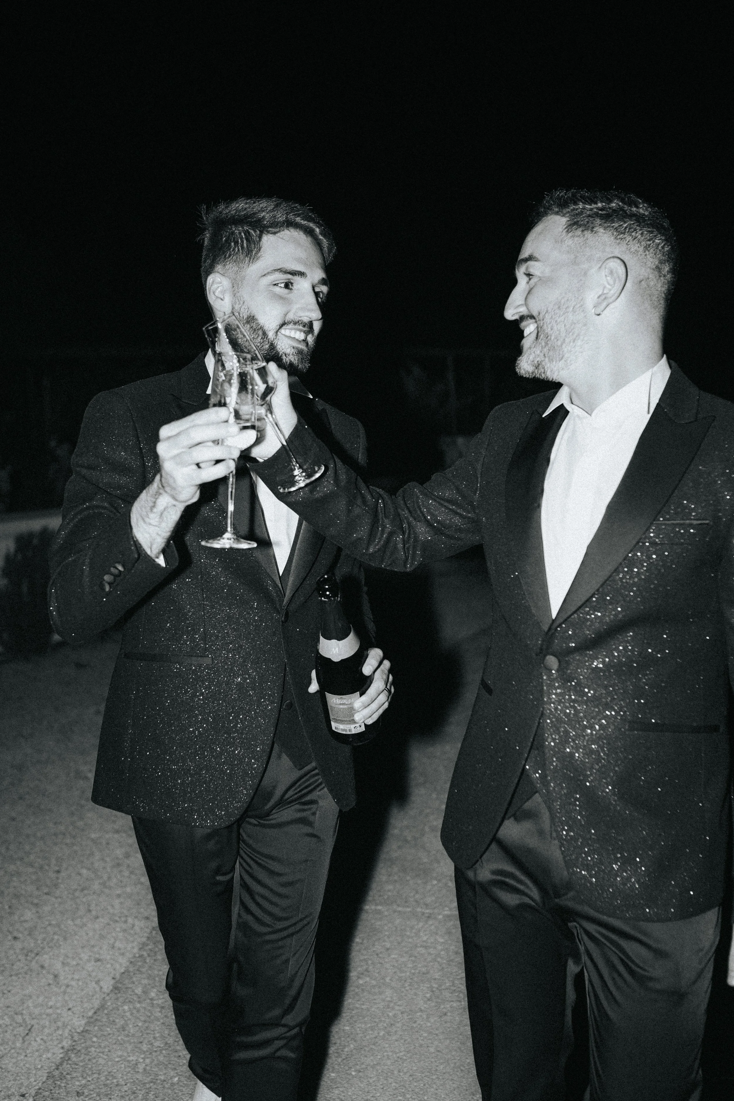 Two grooms celebrating with champagne during their wedding 