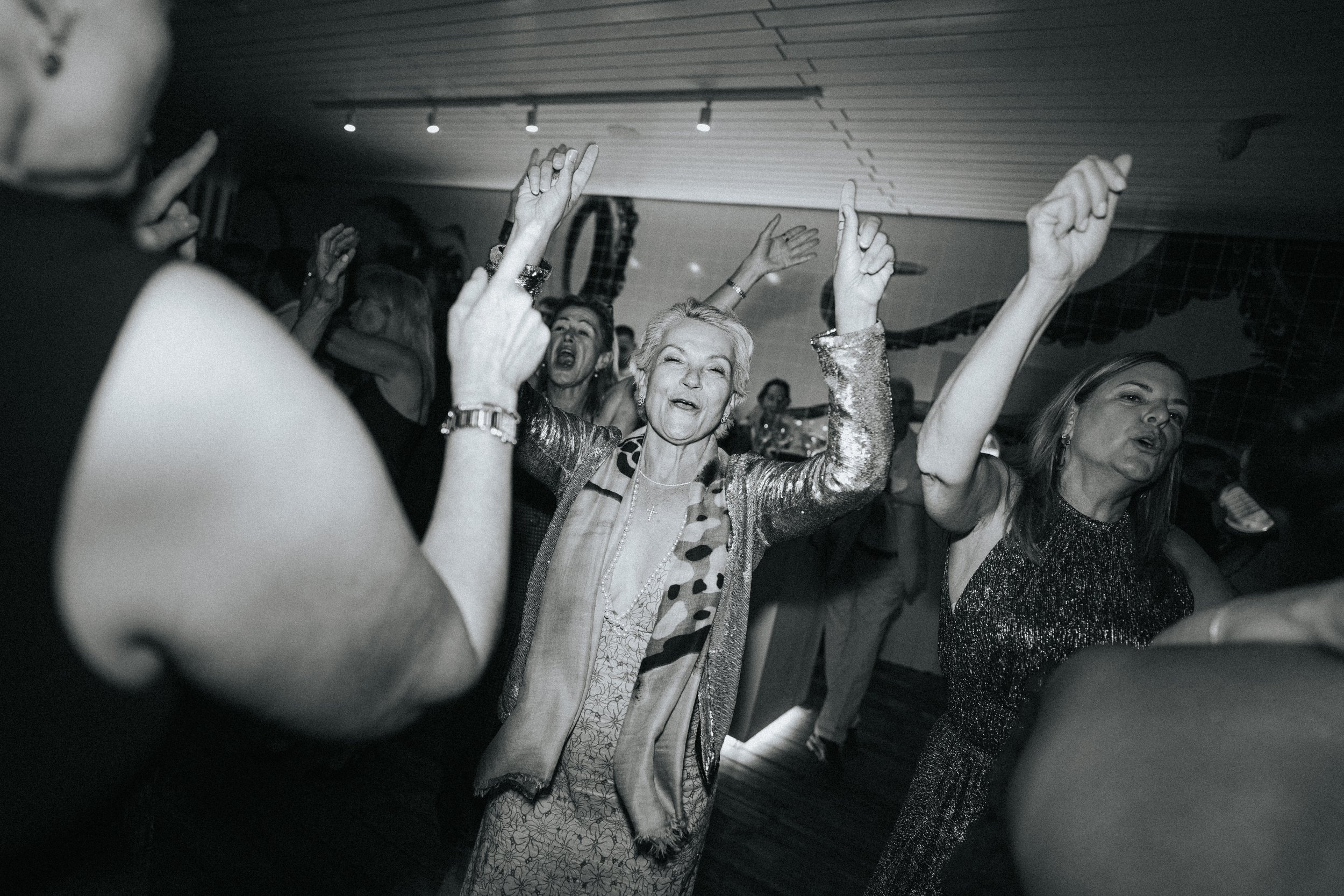 People dancing and enjoying themselves at a party or celebration in an indoor venue.