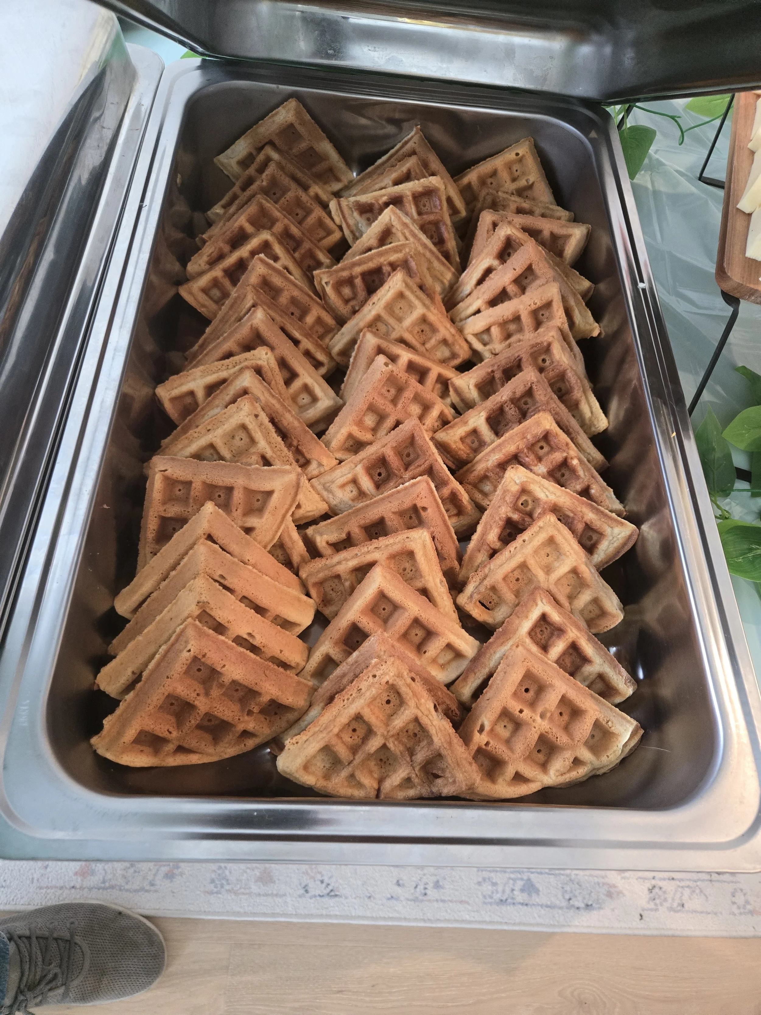 Stainless steel catering tray filled with golden toasted waffle pieces by Acento catering in Austin TX