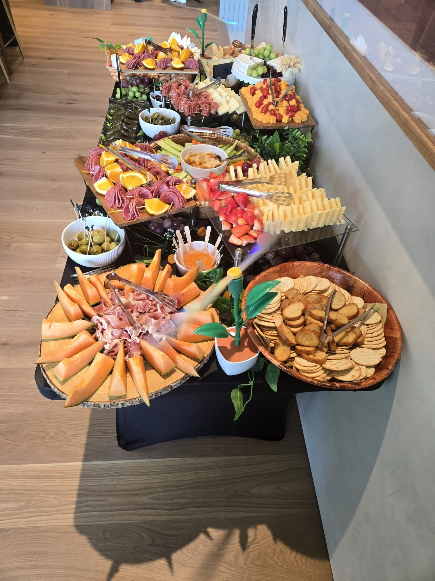 Gourmet grazing display featuring fine cheese, charcuterie, fresh berries, and citrus on wooden boards by Acento ATX