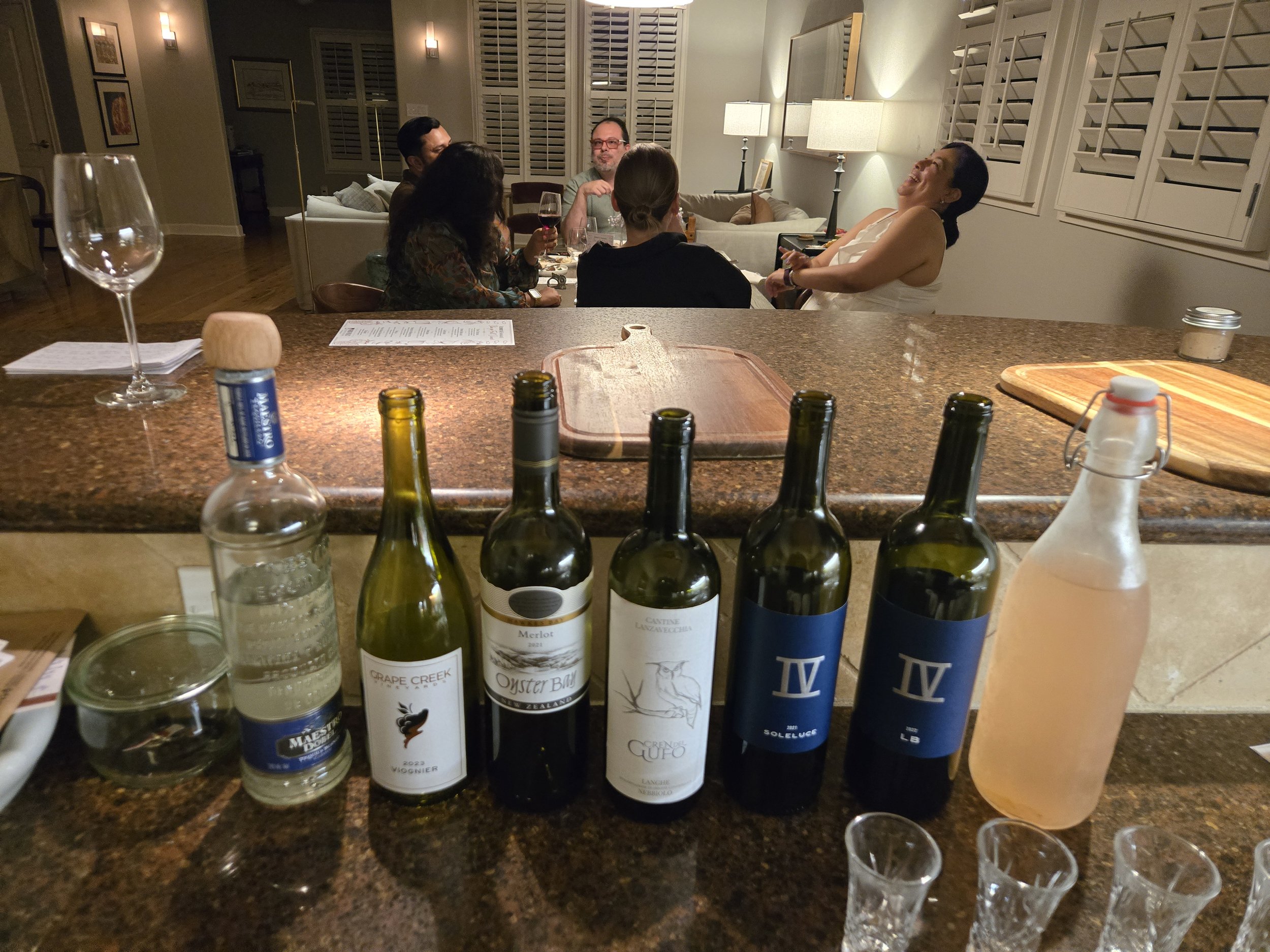 Guests enjoying a cozy private catered dinner with wine and conversation hosted by Acento catering in Austin TX