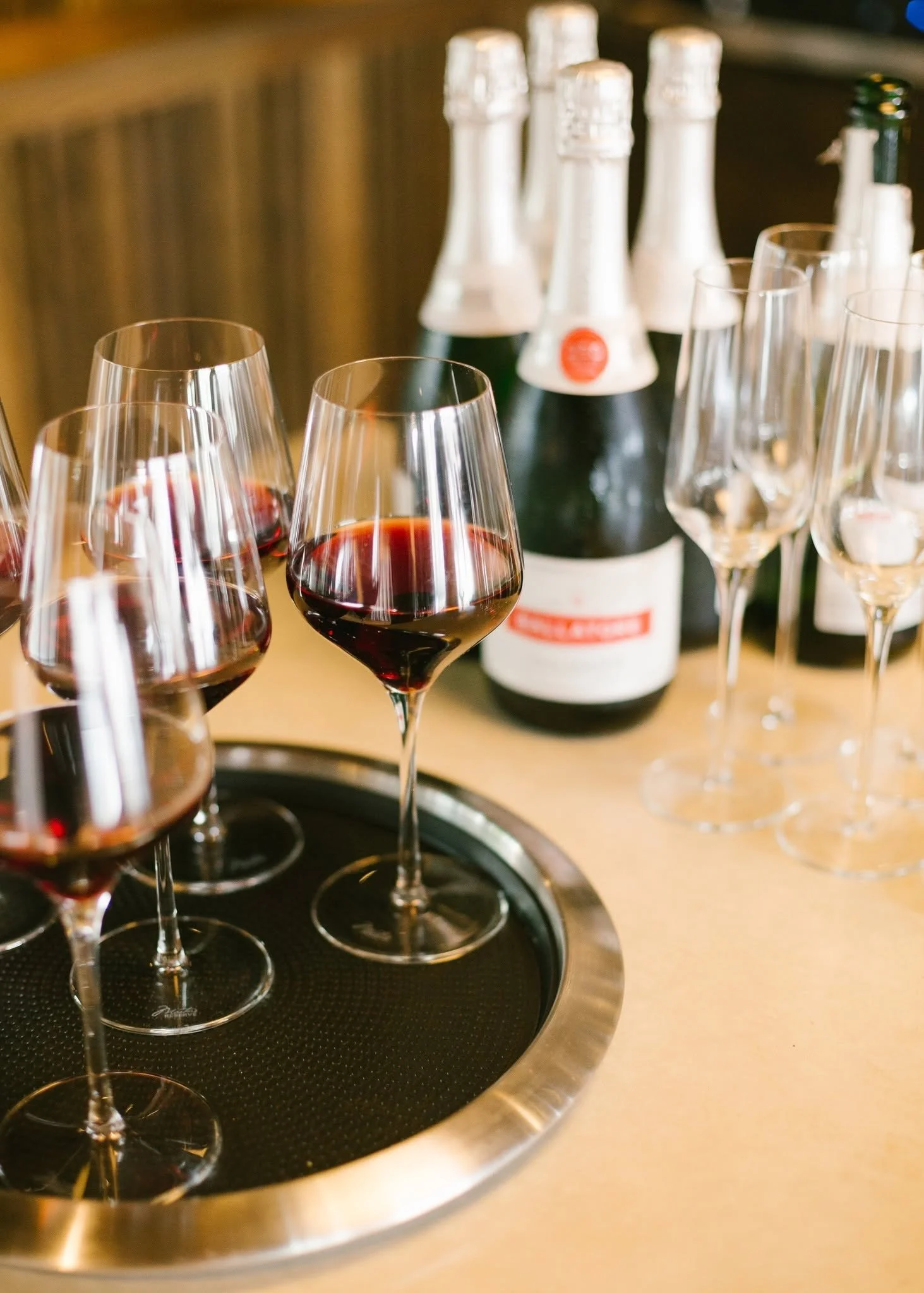 Wine and champagne service by City Catering in Knoxville featuring red wine glasses, champagne flutes, and bottles arranged for an event bar.