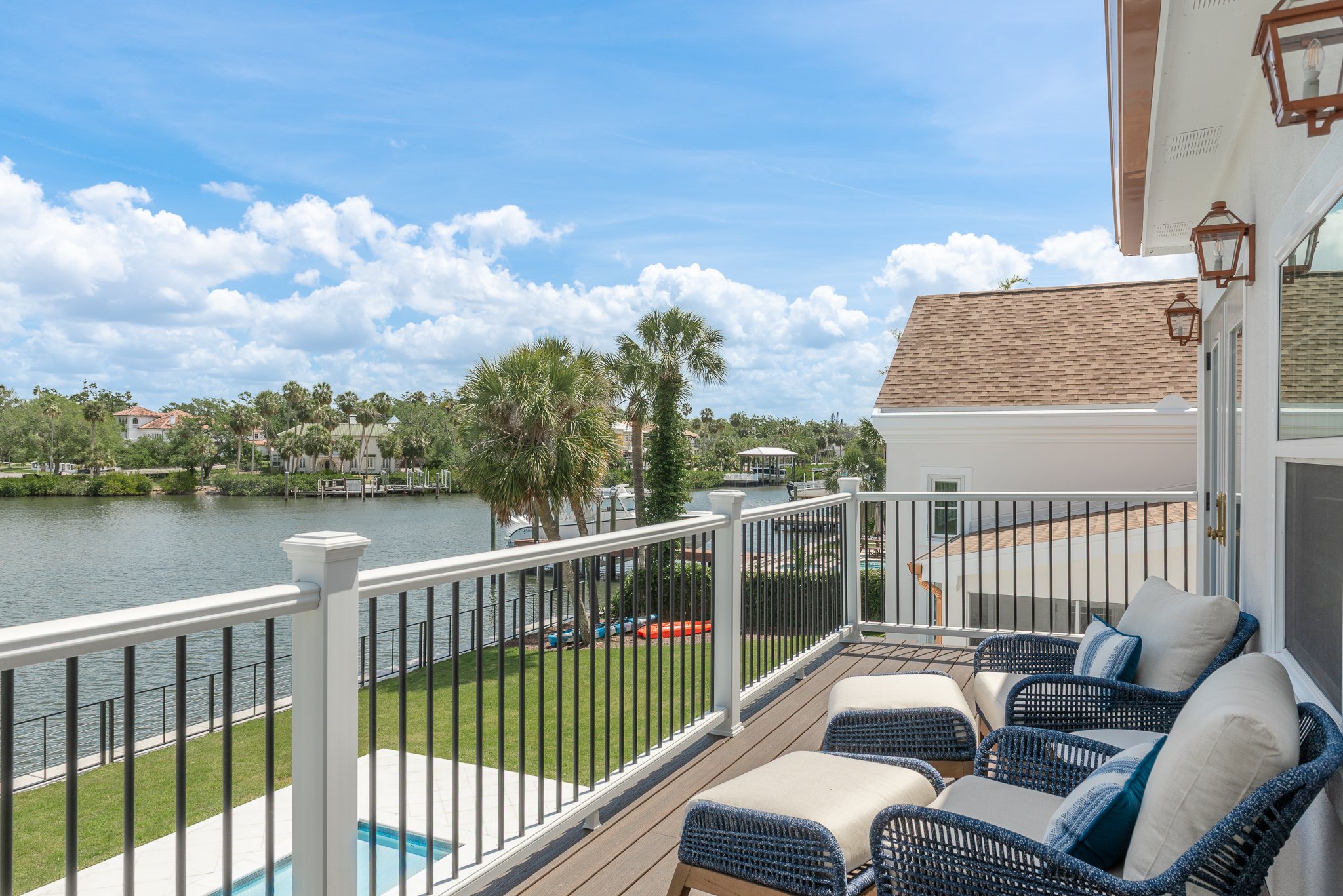 a beautiful deck with furniture facing marina and the in-ground pool after a complete whole home remodel in Tampa | Lindross Remodeling