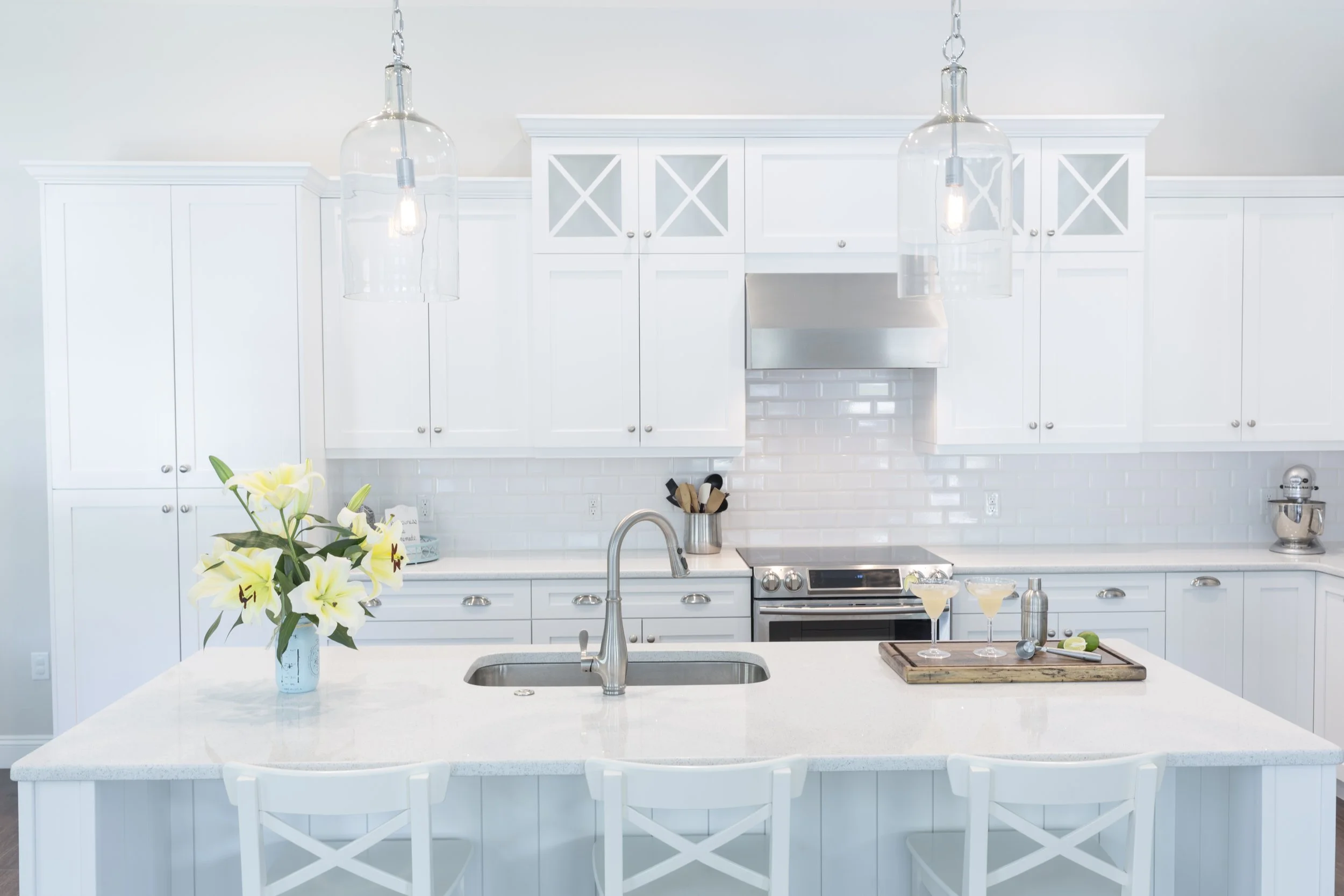 white pristine custom kitchen by Lindross Remodeling with a a sink in the Island
