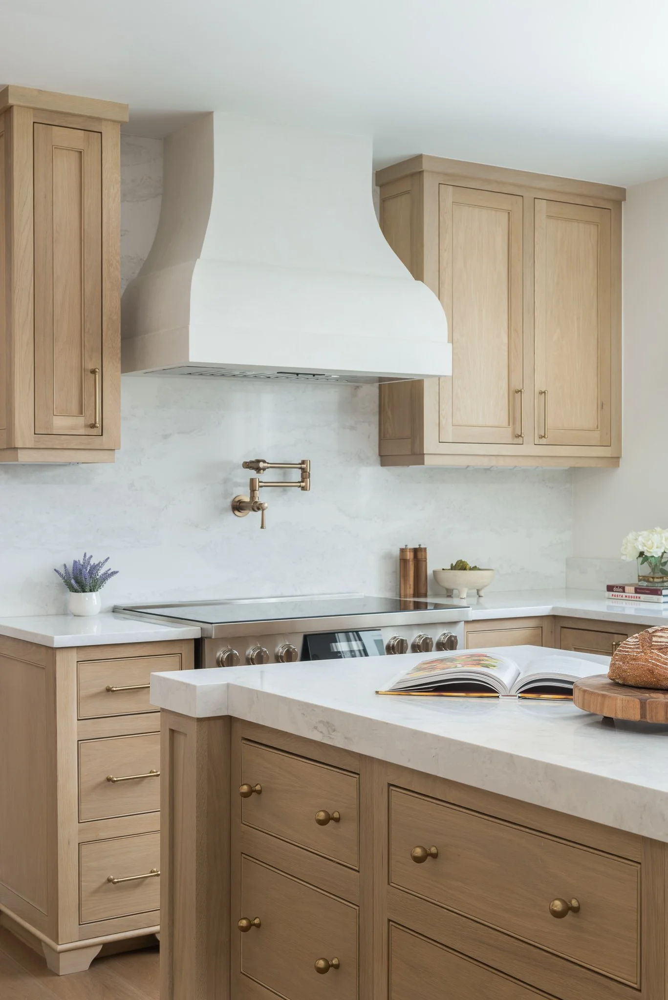 white oak kitchen cabinetry and a plaster range hood in a clearwater kitchen