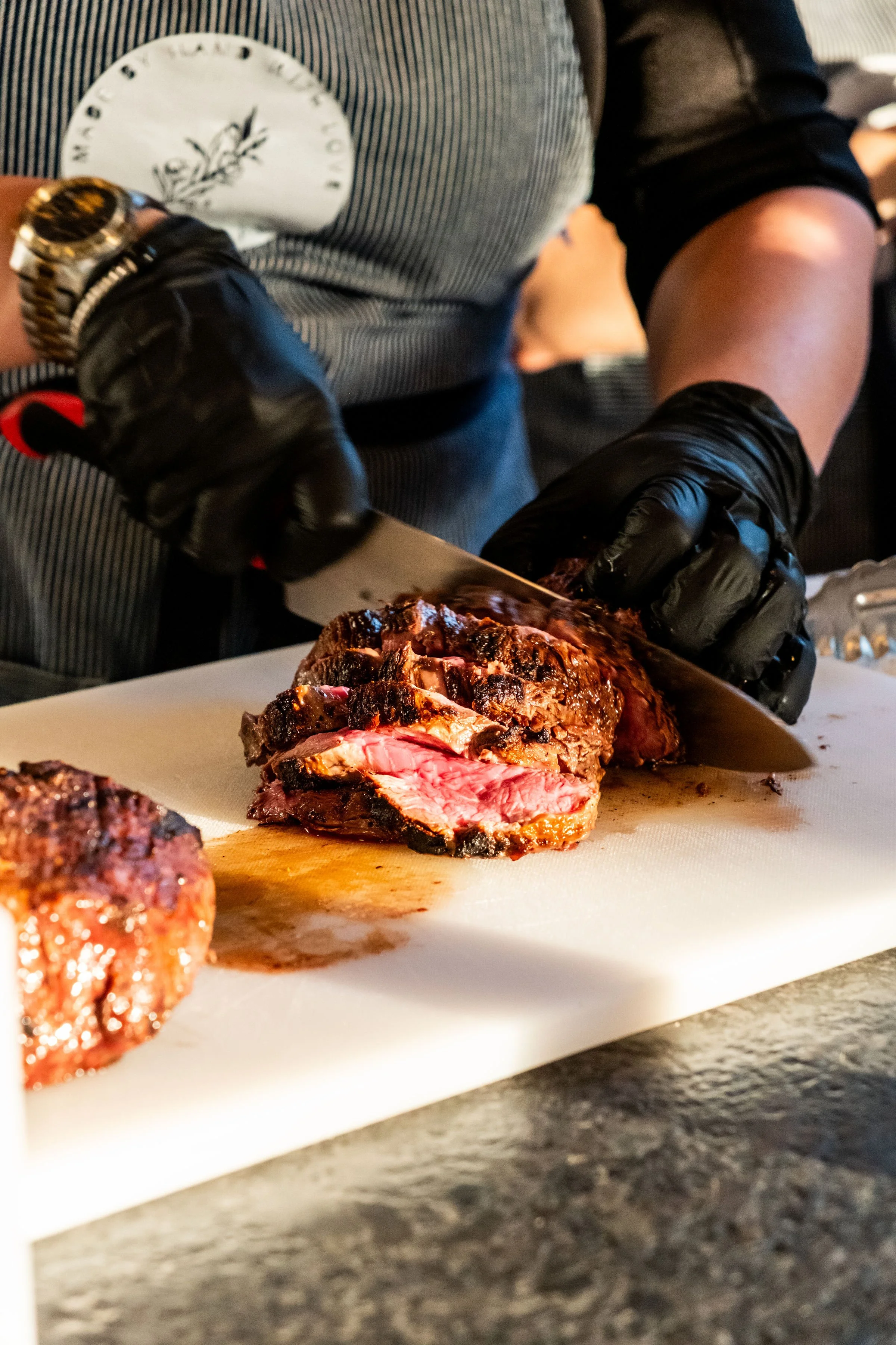 close-up of a chef cutting steak at a private party in south tempa at a custom Backyard Covered Patio