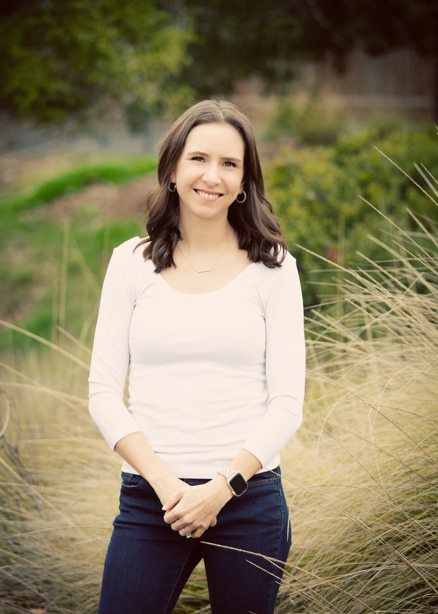 perinatal therapist brittany sallaberry standing in a field smiling