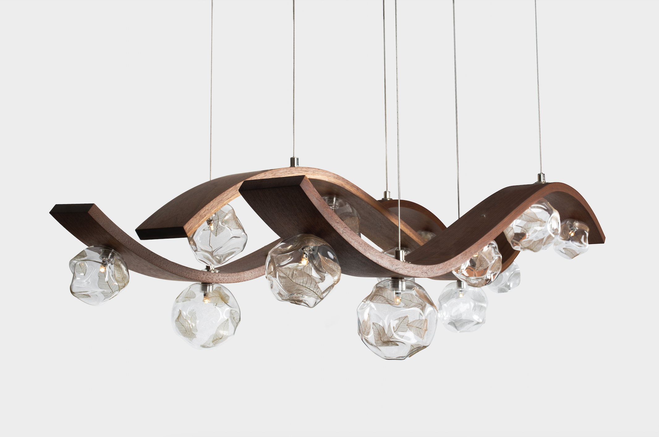 Modern chandelier with a wavy wooden frame and multiple glass orbs hanging from thin wires.