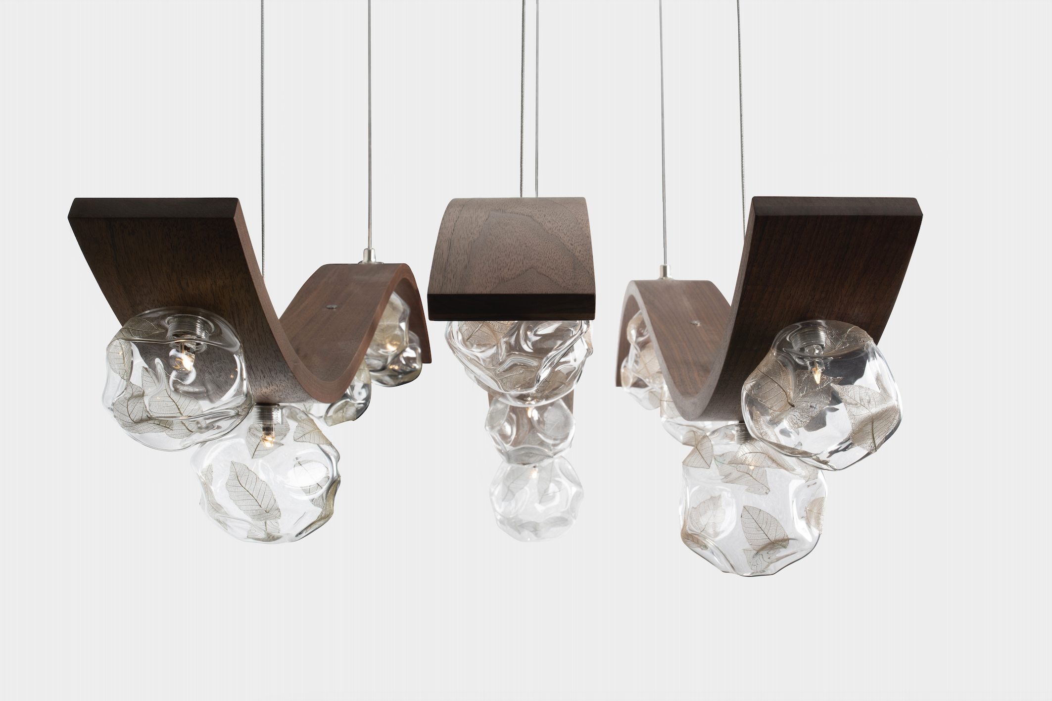Modern chandelier with clear glass globes and wooden accents hanging from cords