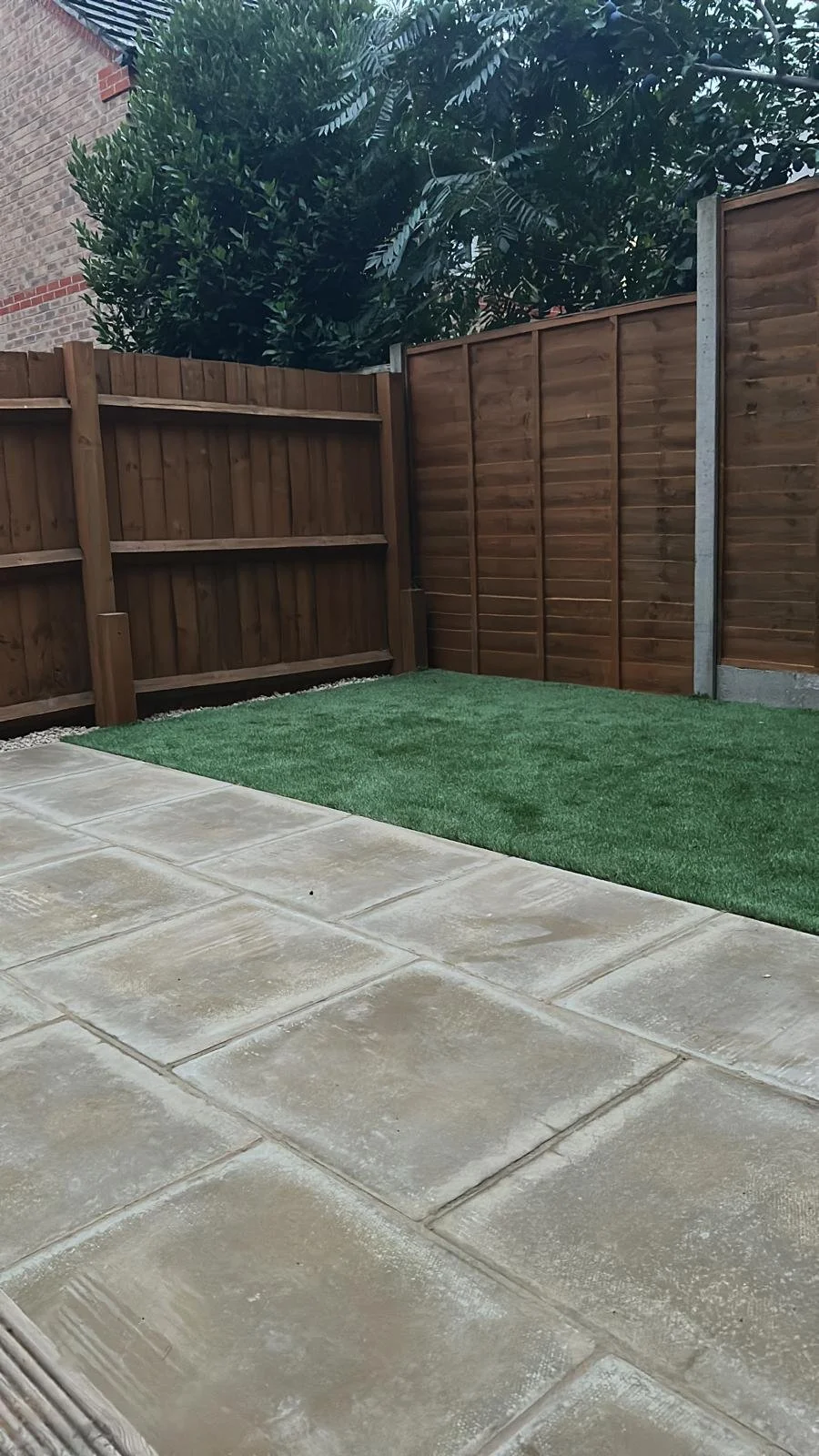 The finished result: a complete garden transformation. Fresh fencing, a stylish new decking area, crisp slabs, and low-maintenance artificial grass all working together to create a space that’s as practical as it is beautiful.