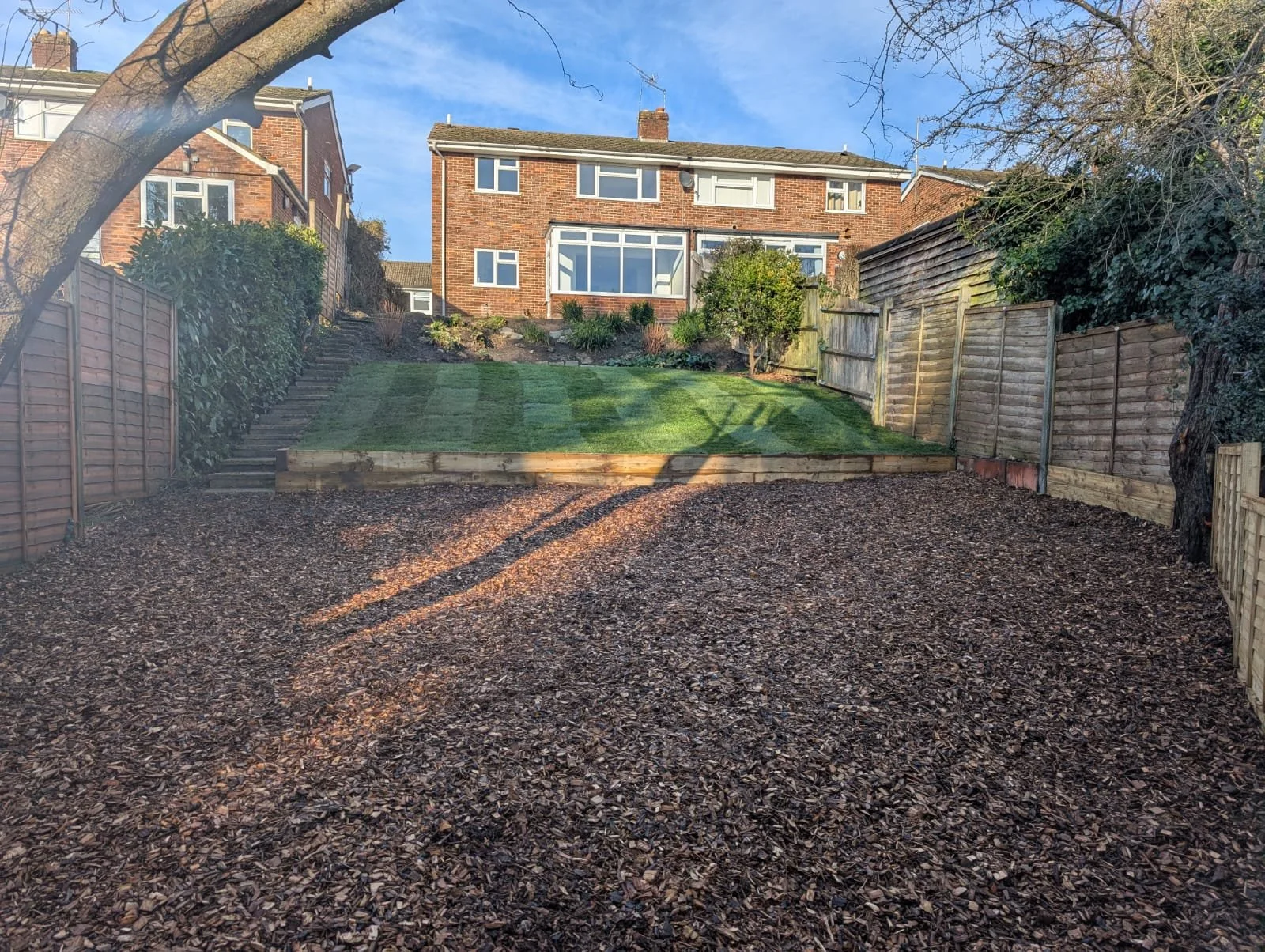 To complete the transformation, fresh turf was laid across the upper level, restoring a clean, usable lawn. New fencing was installed along the rear boundary to properly close off the lower section, giving the entire garden a defined, cohesive finish