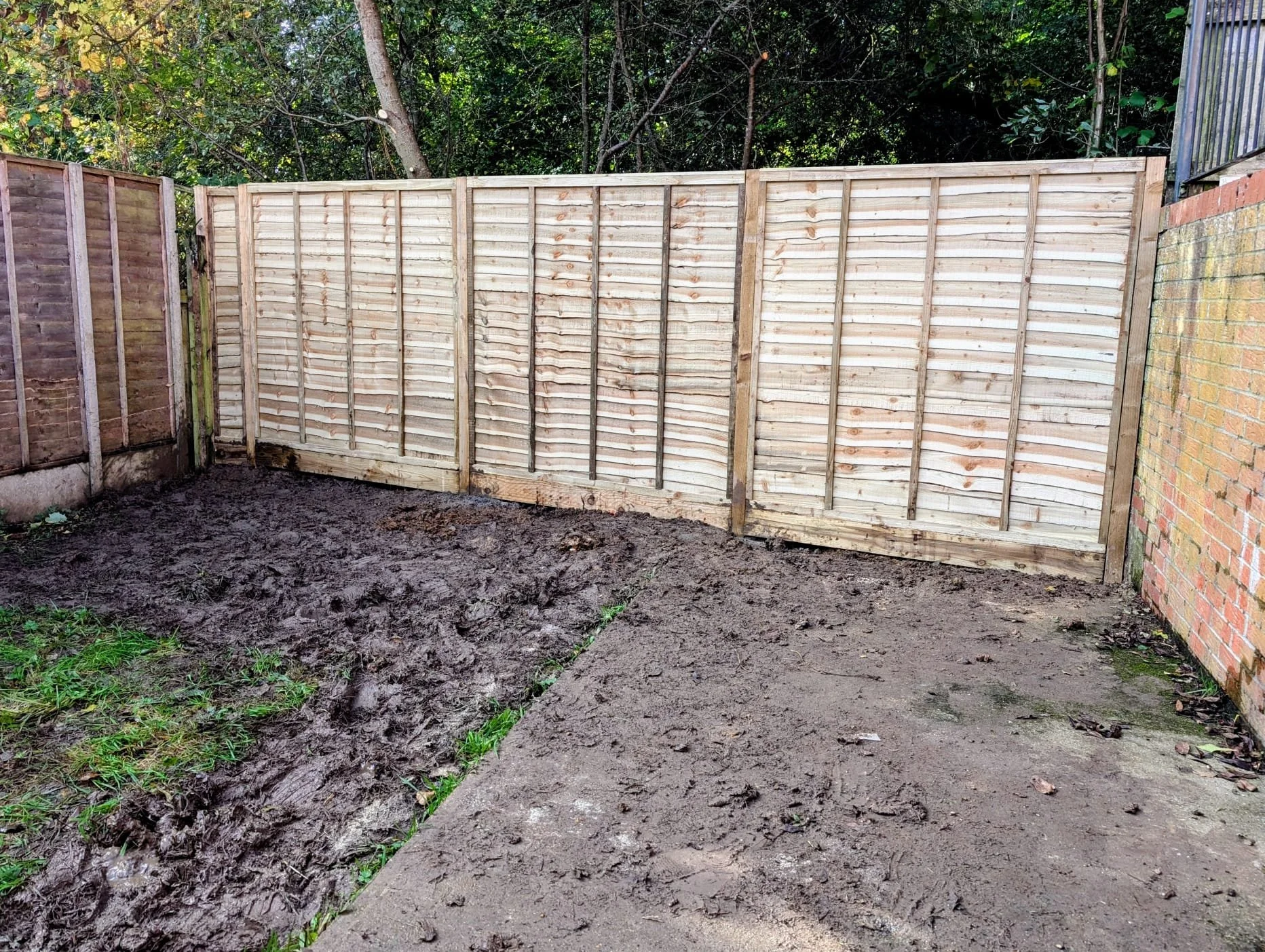 With the overgrowth cleared, the true state of the space was revealed: a marshy, clay-heavy ground layer that offered little promise on its own. At the same time, the old, crumbling fence was replaced with a brand new boundary, immediately bringing s