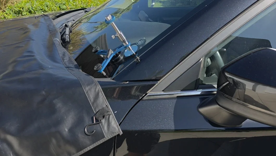 Close-up of a car's windshield with a radar gun mounted on the dashboard for speed measurement.