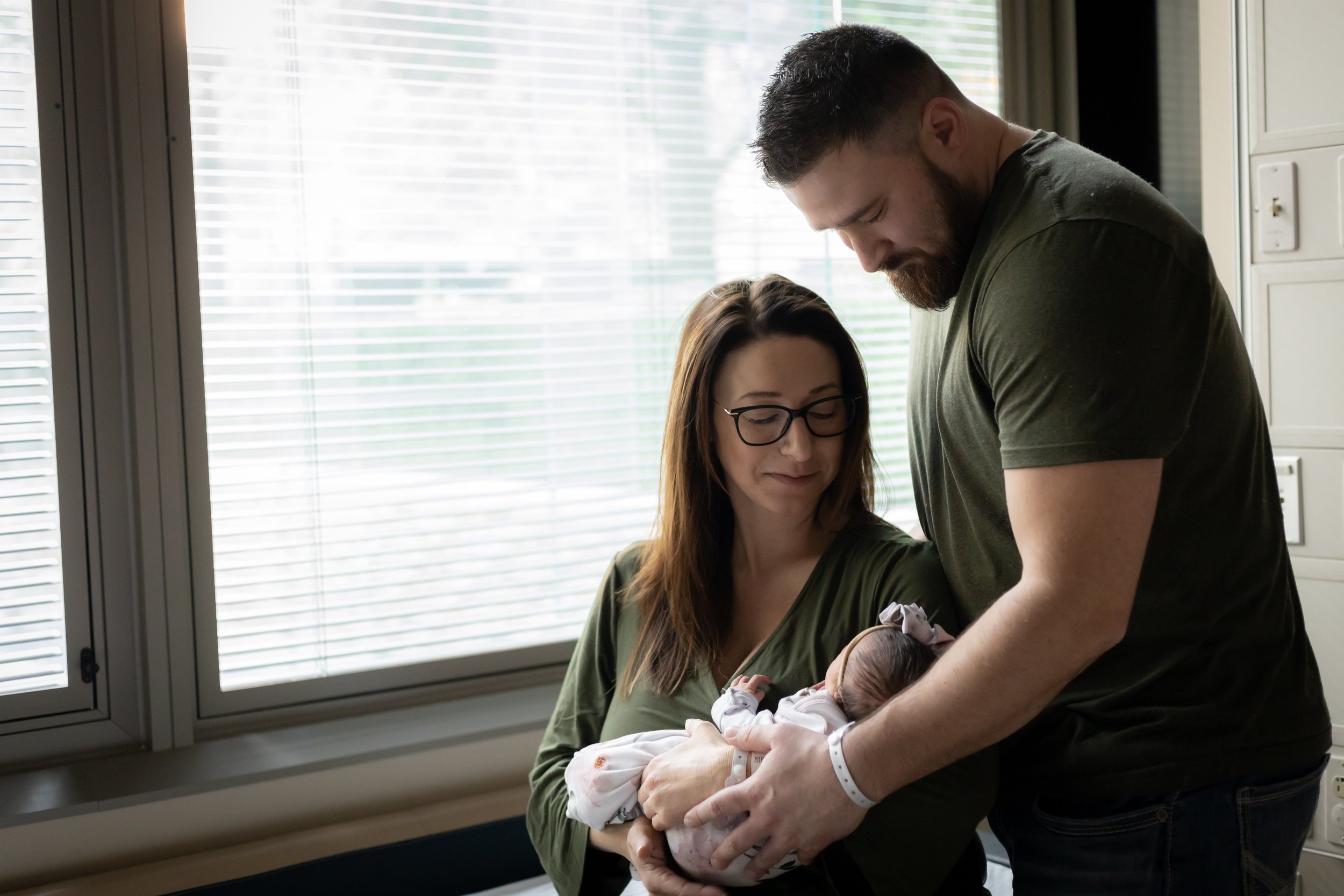 A young couple smiling while holding their infant. (Copy)