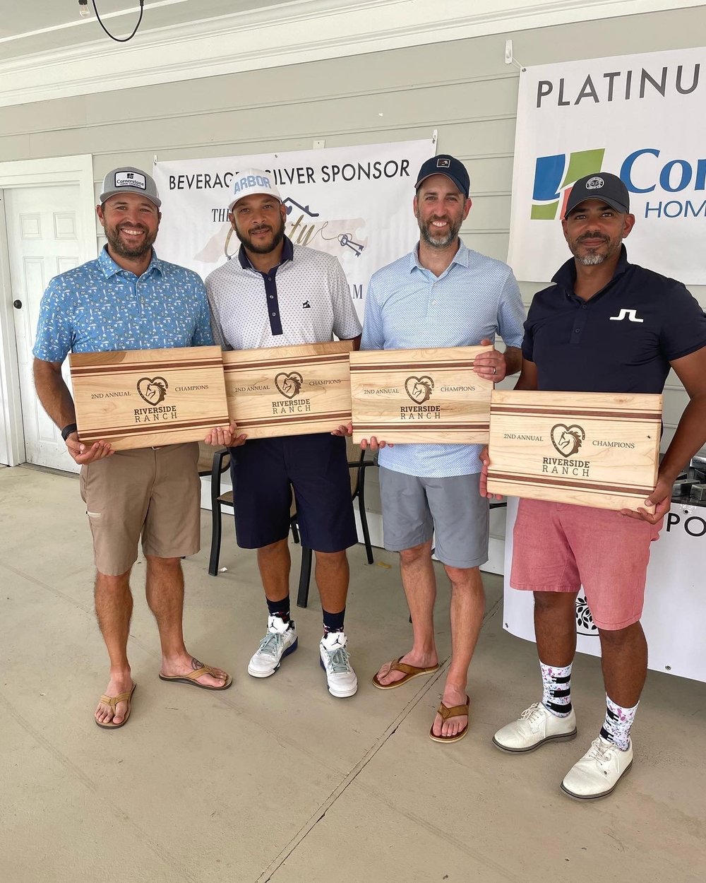 A group of golfers smiling and posing with Riverside Ranch plaques. (Copy)