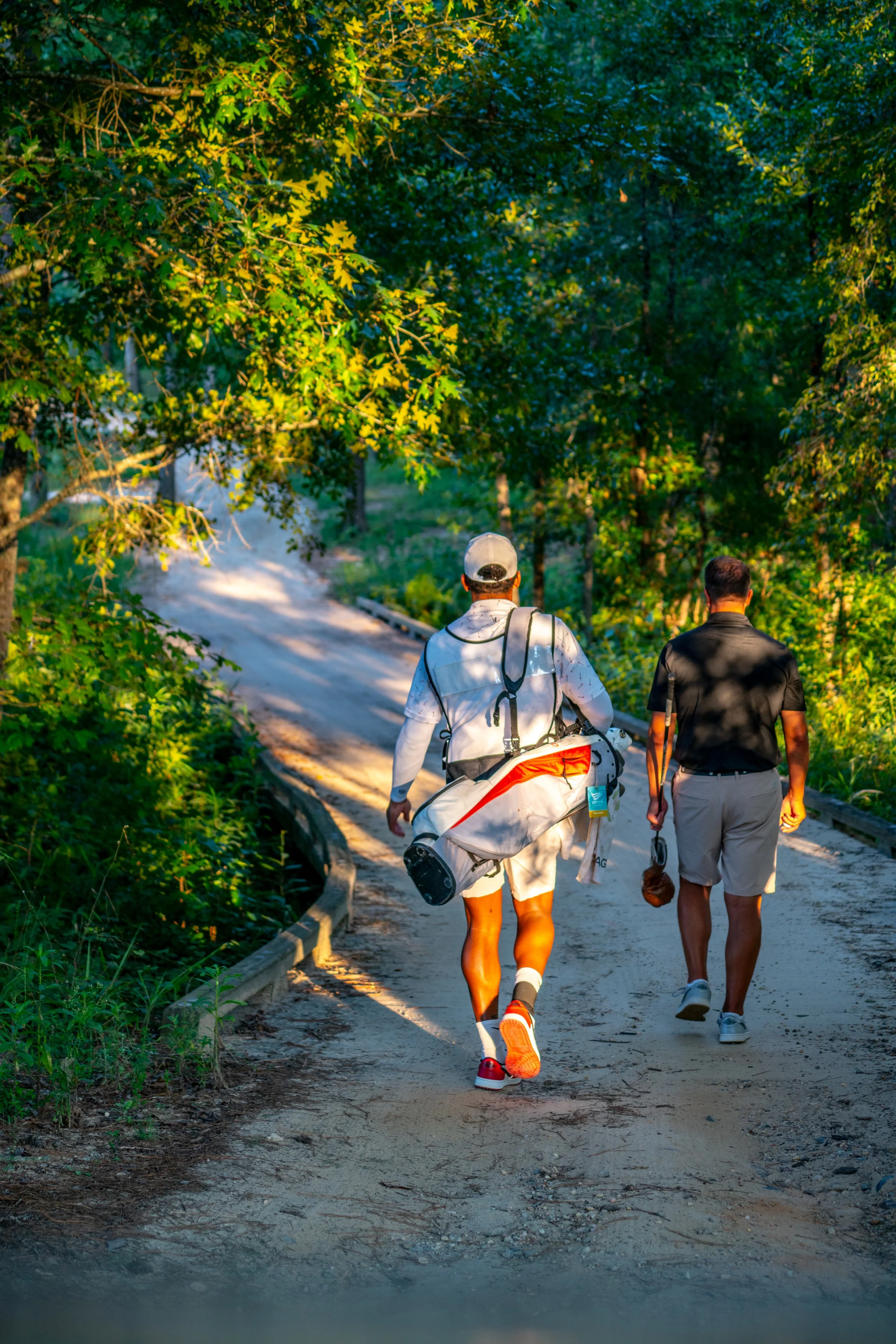 Brian Schenk walking with caddie at Dormie Club