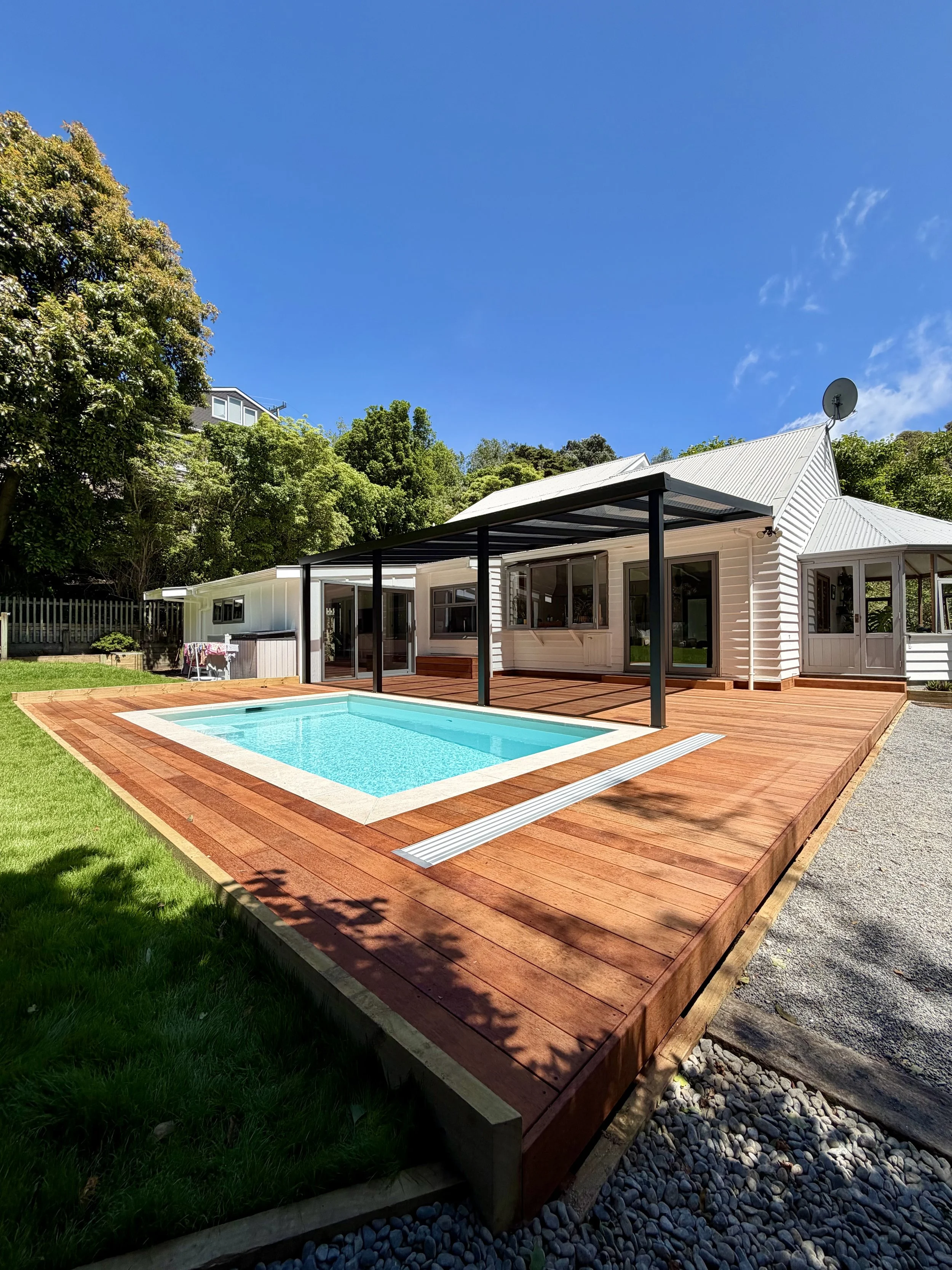 Landscaping project with Kwila decking, in-ground swimming pool and custom pergola