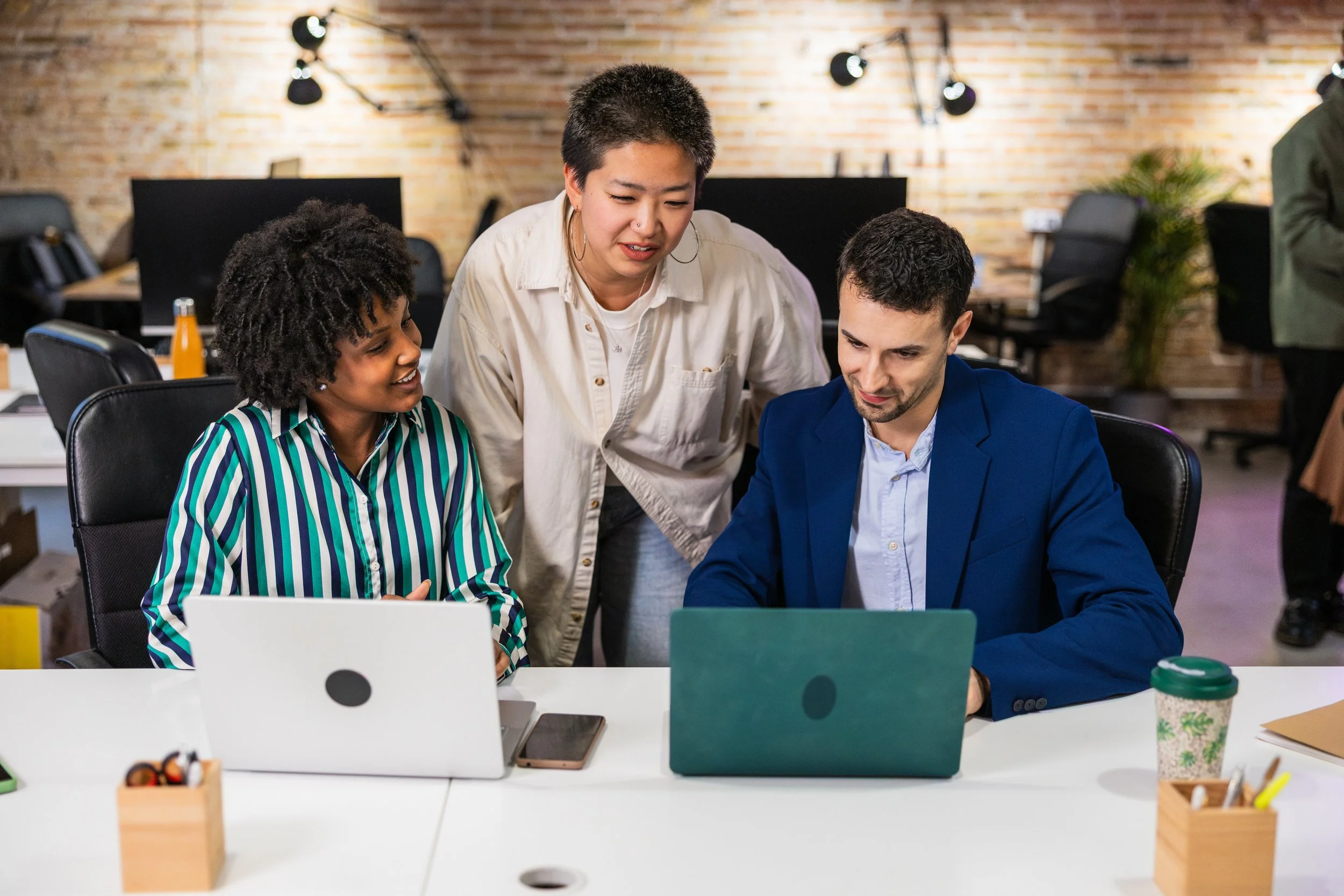 a team of people at a business working on laptops