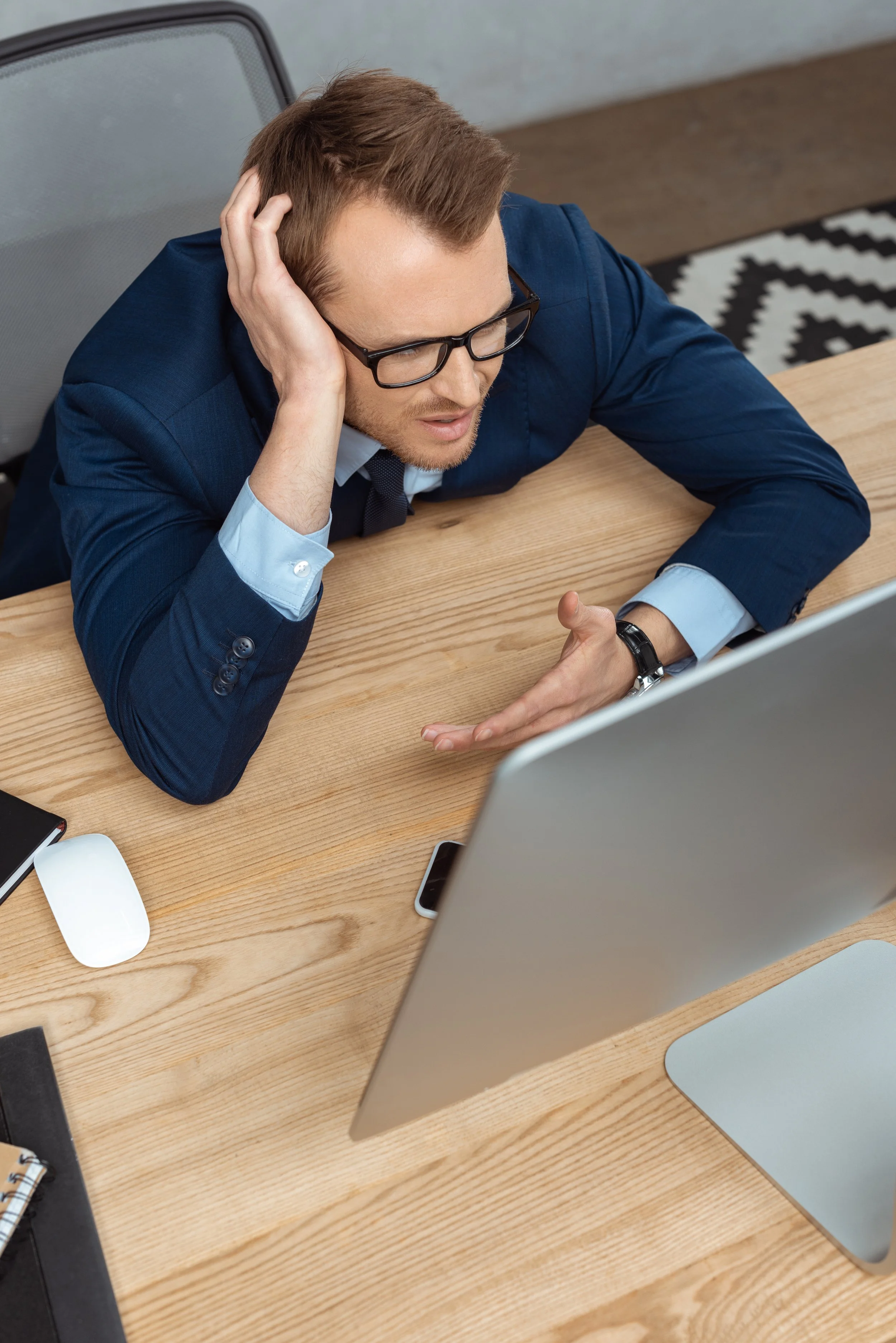 frustrated businessman looking at a computer during unexpected IT downtime