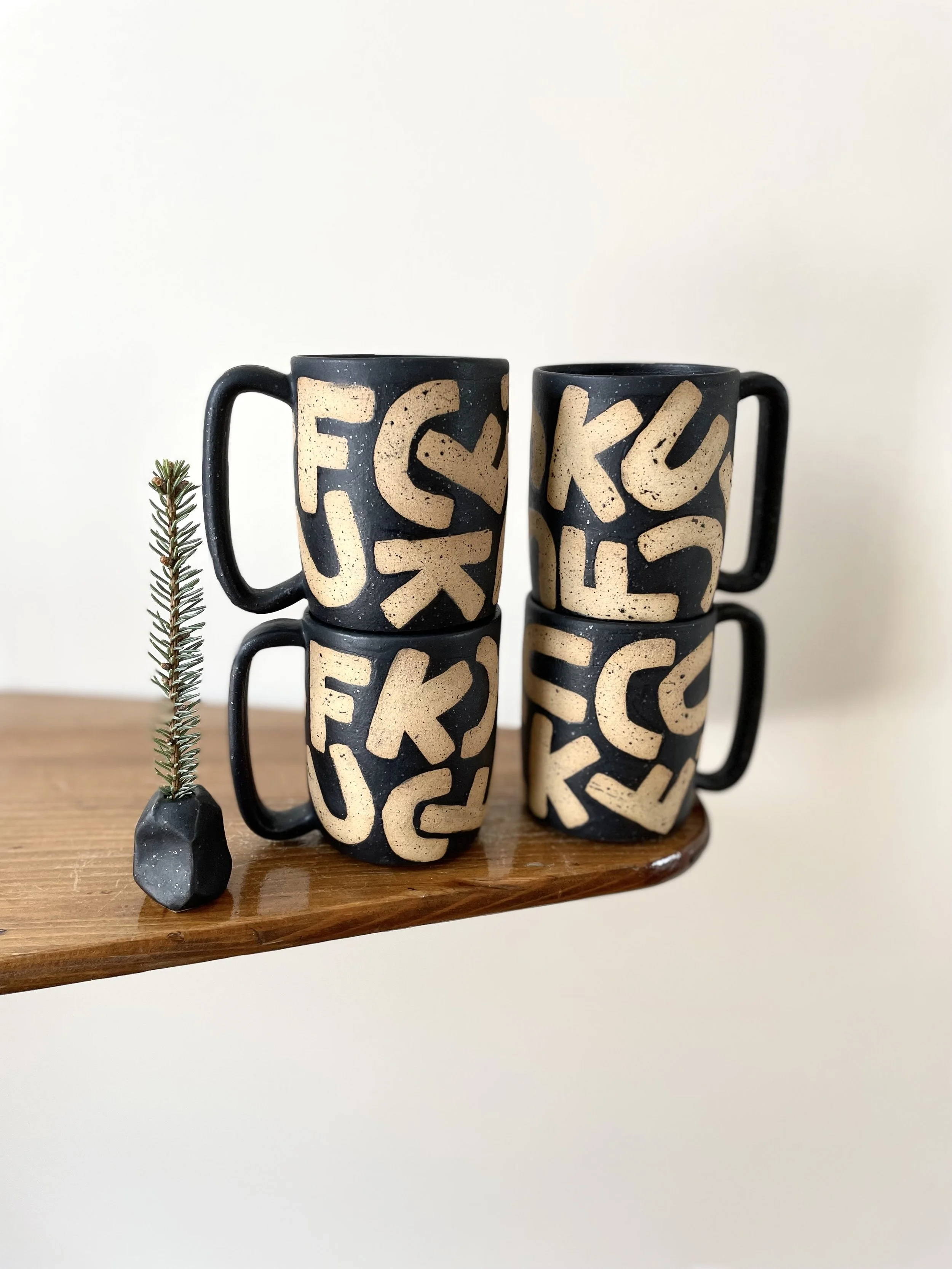 FCUK Mug in matter black, with raw speckled letters