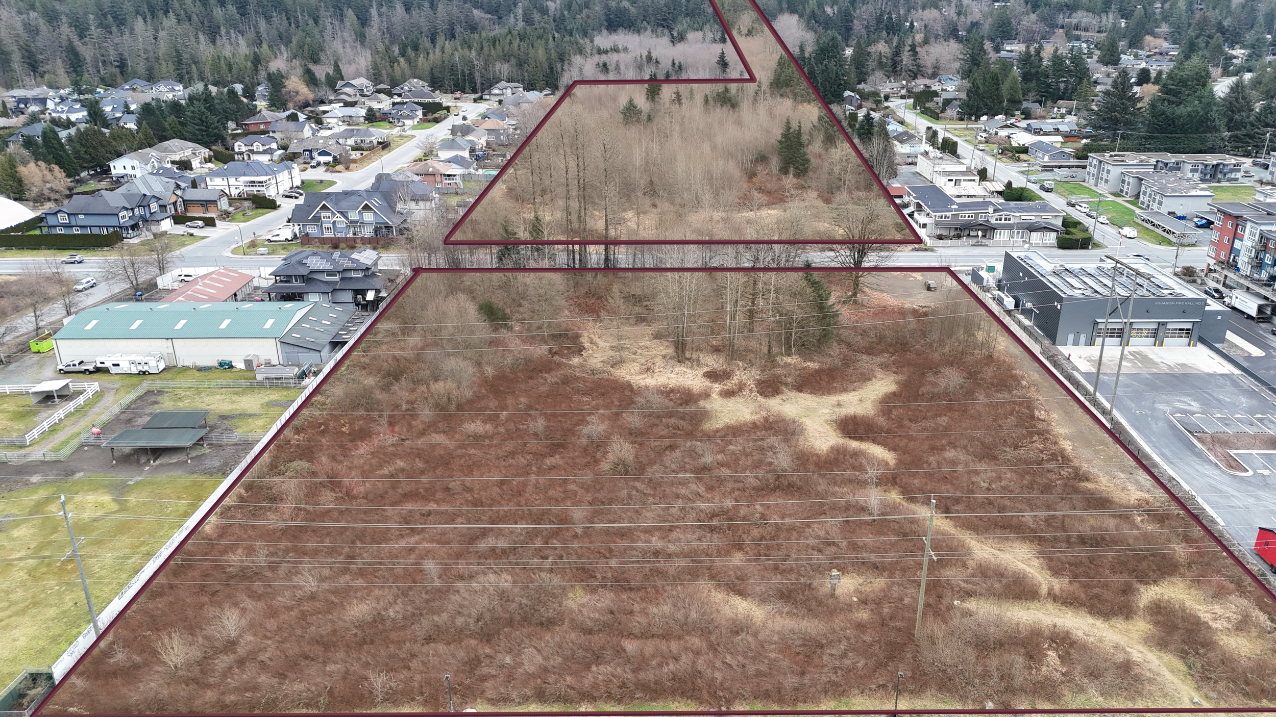 Aerial view of a suburban neighborhood with a large open lot outlined in burgundy, showing trees and brownish grass within the lot.