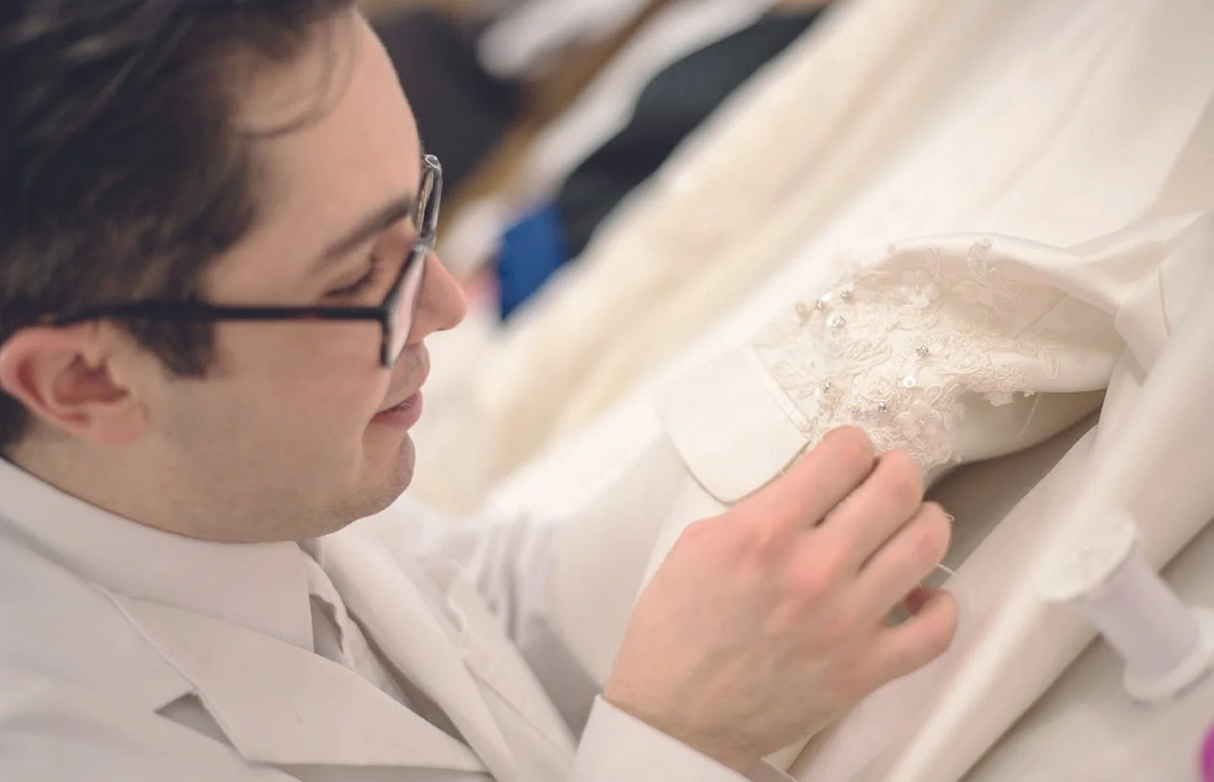 Fashion designer Michael Zoffranieri hand sewing applique and beads on to a dress