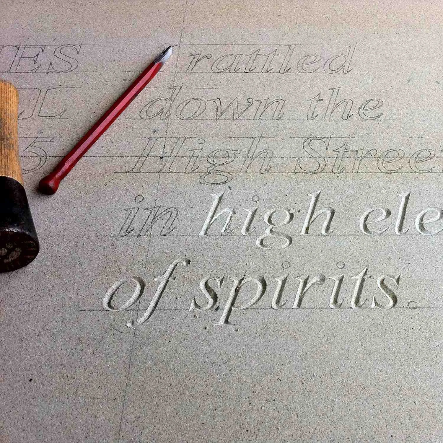 letters being carved into sandstone