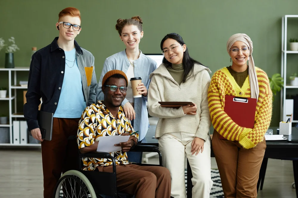 A team gathered around a laptop collaborating
