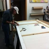 Person assembling a foosball table in a workshop.