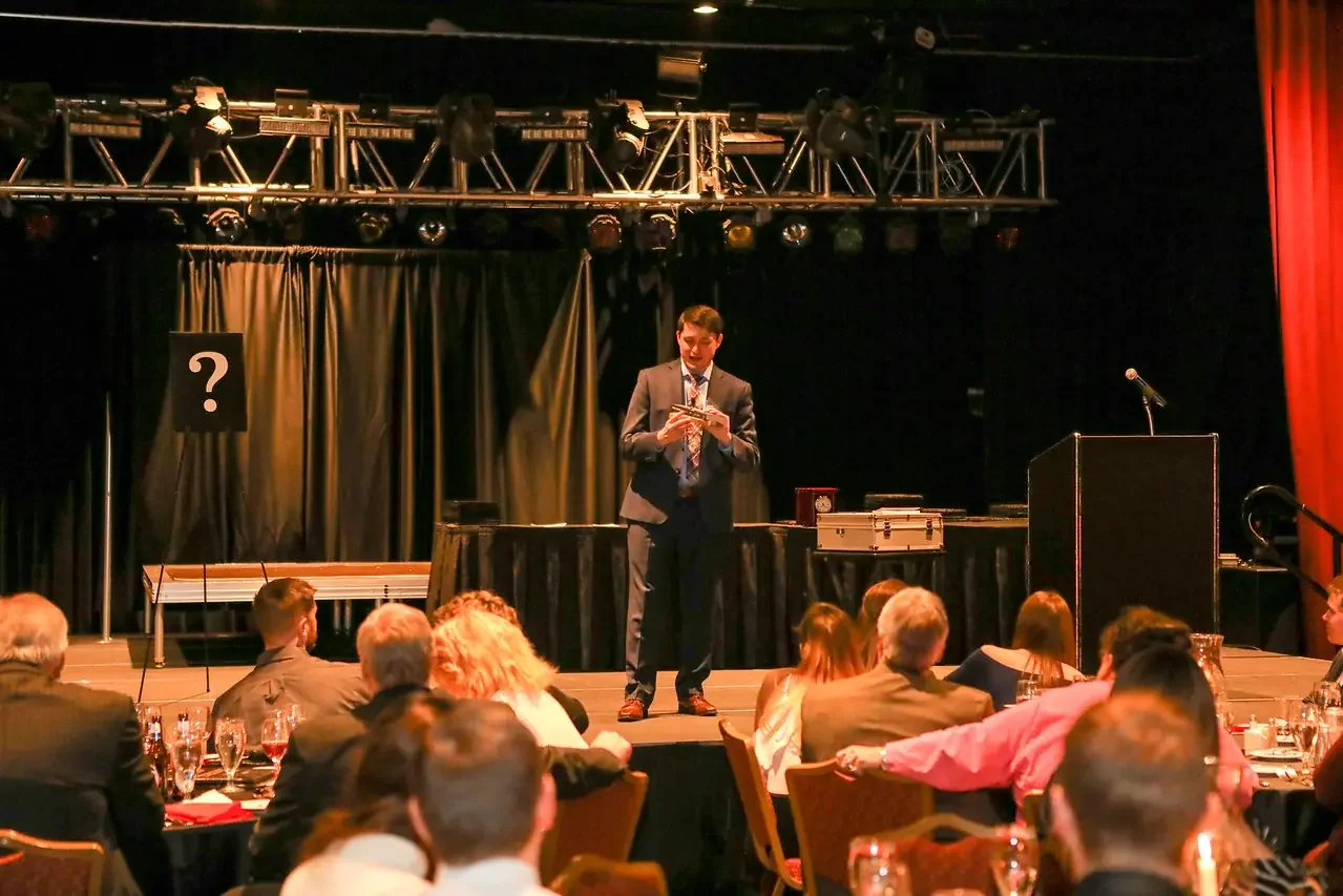 Corporate event magician Josh Weidner performing close-up magic for business guests