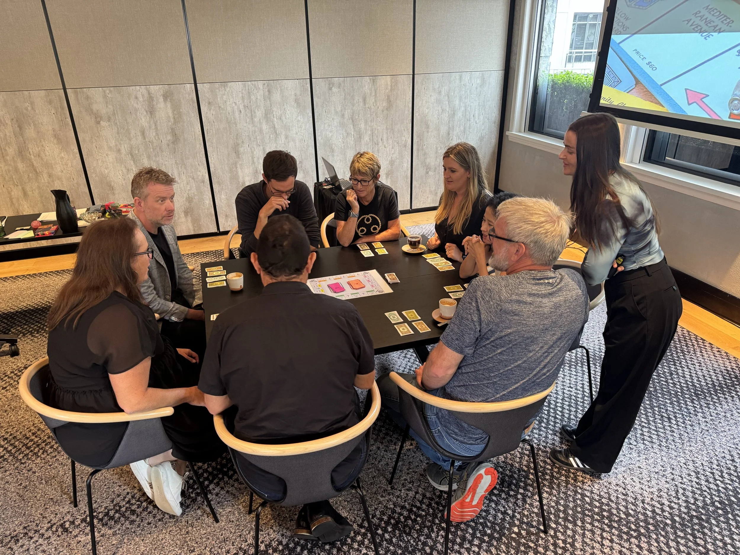 Participants collaborating in a facilitated small-group workshop around a table.
