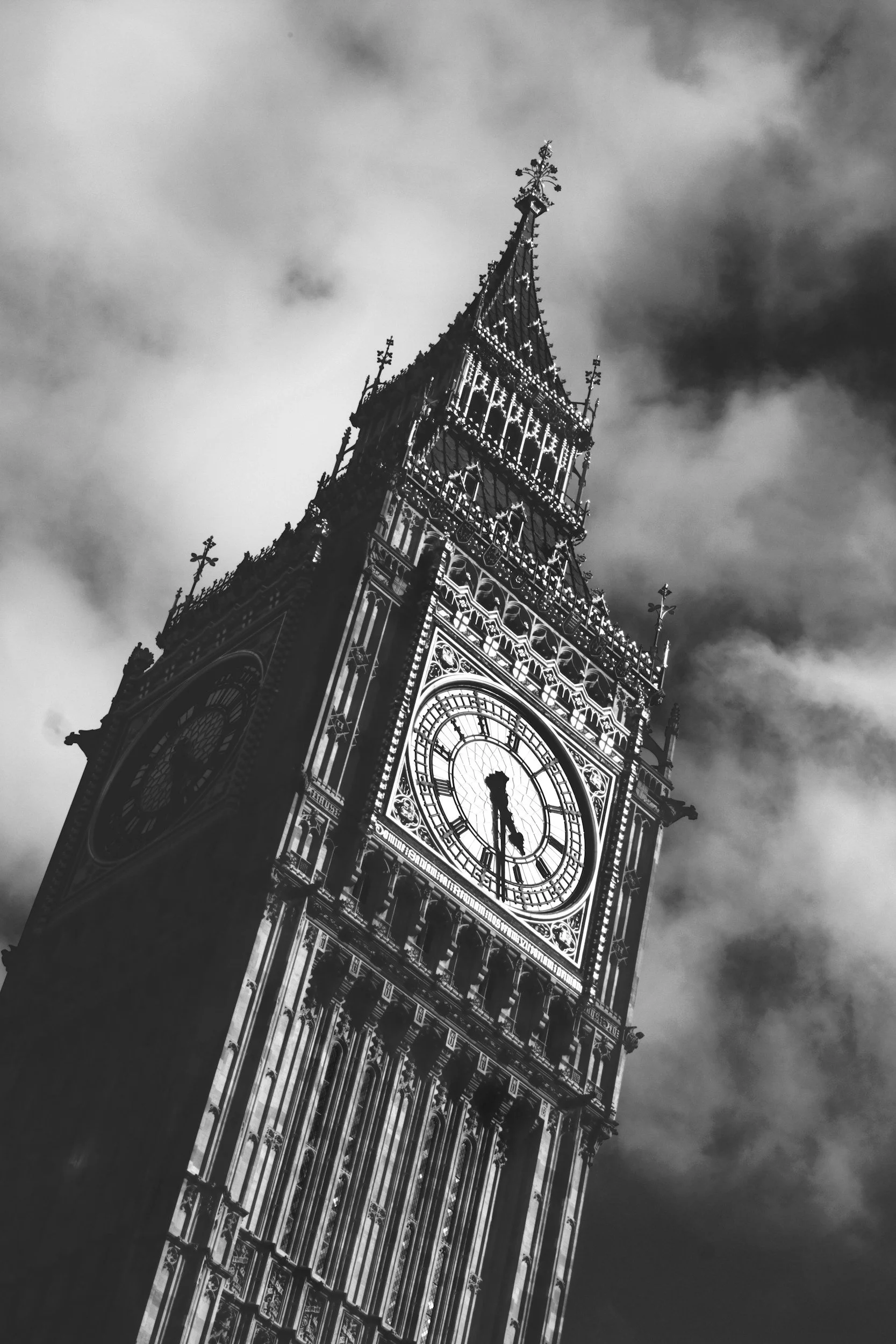 Black and white photo of Big Ben clock tower against a cloudy sky.