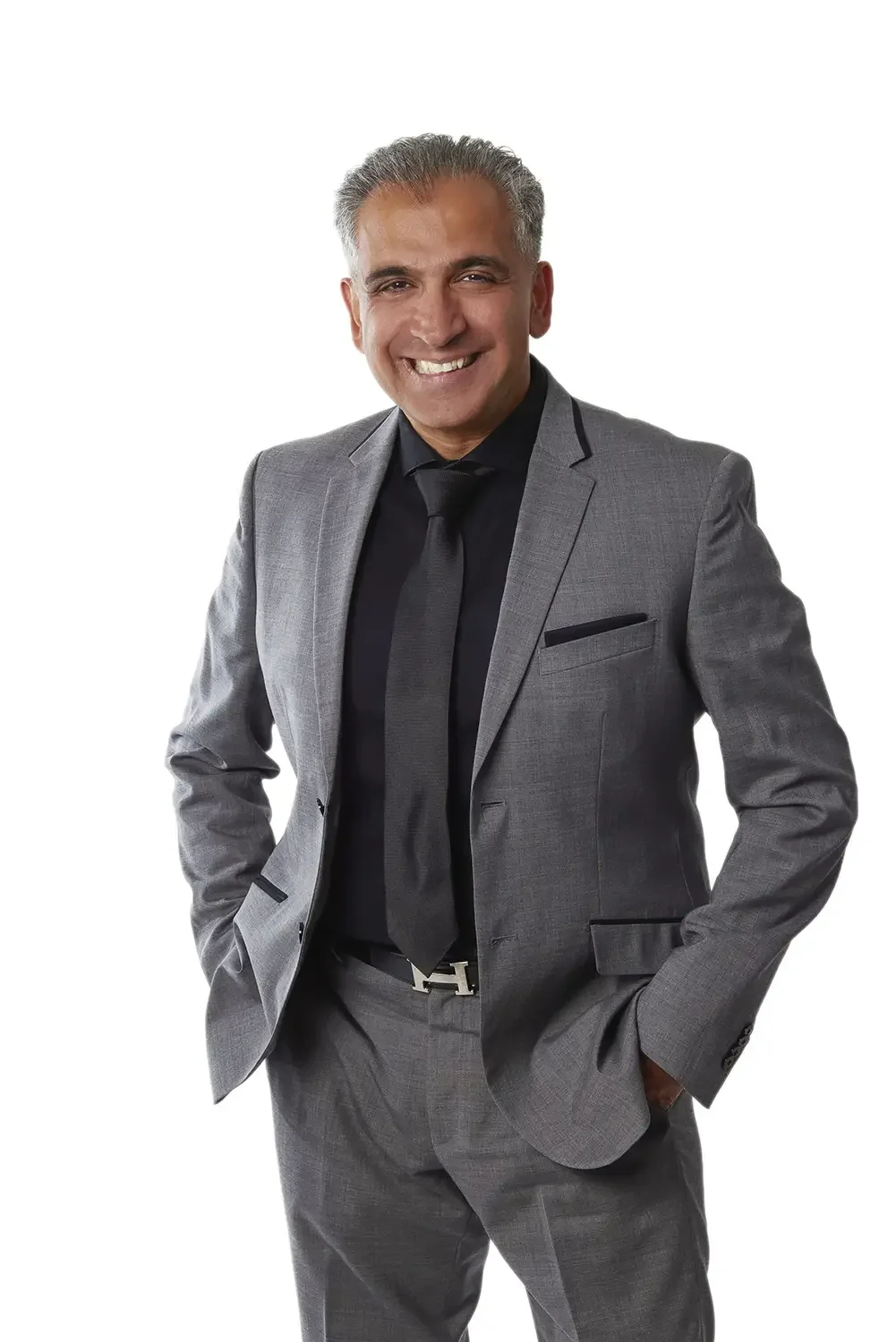 A business portrait of a smiling man in a grey suit against a white background.