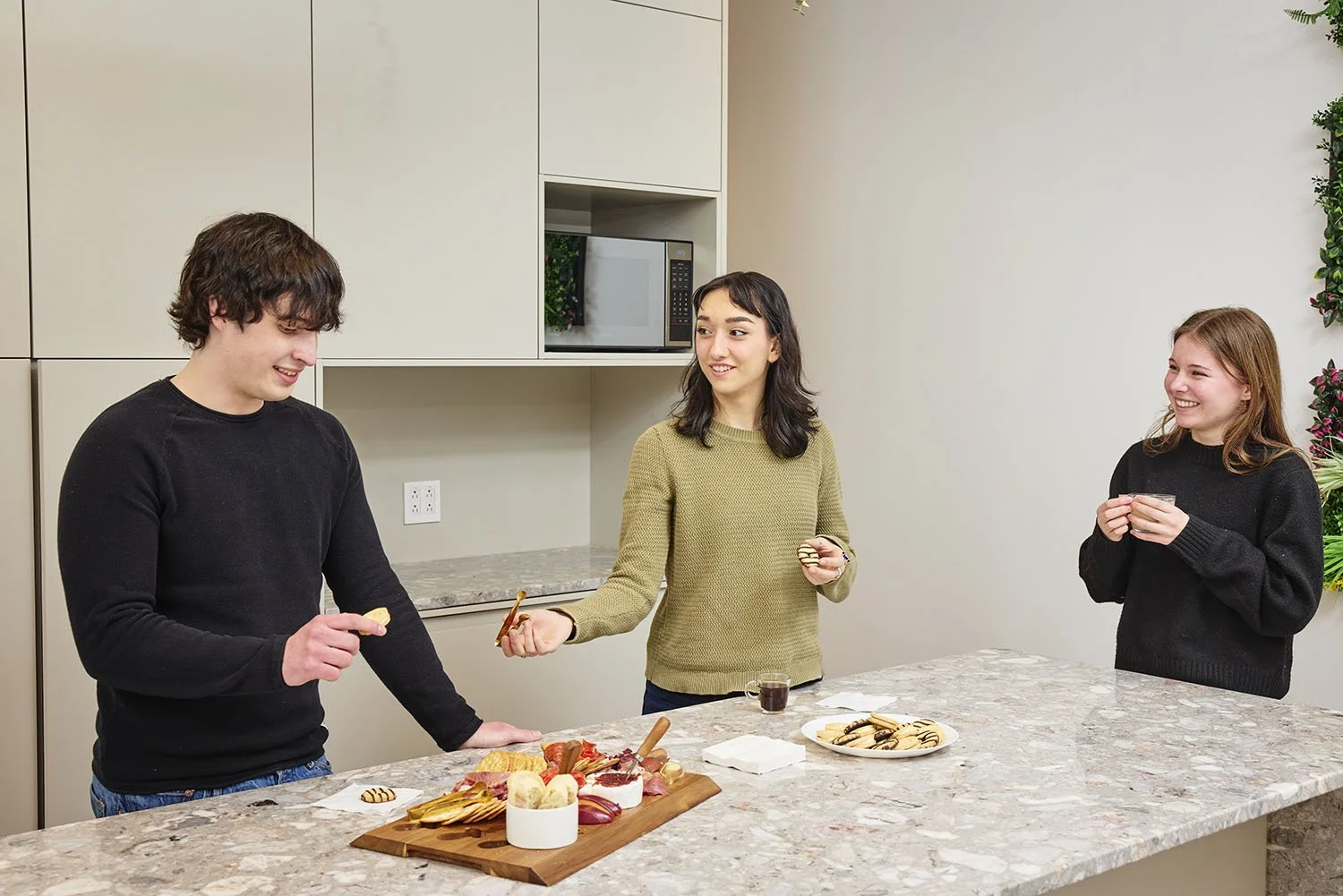 A lifestyle photo of some young adults preparing food in the kitchen of a youth hostel in Montreal.