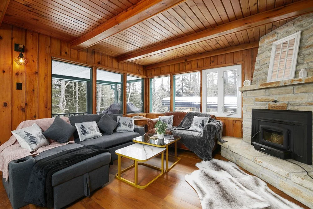 A photo of the living room of a chalet with wood walls and ceiling for an Airbnb listing in Mont-Tremblant.