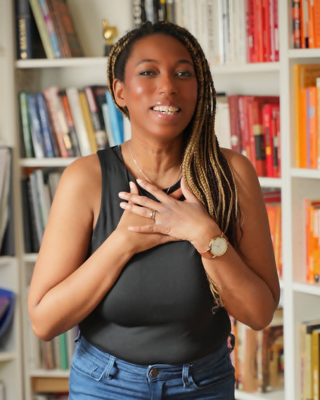 A personal branding photo of a woman posing in front of a bookshelf.