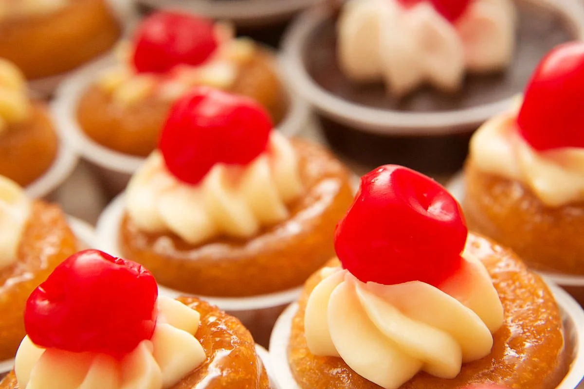 Cupcakes with cherries on top.
