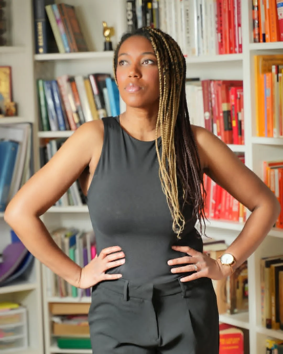 A personal branding photo of a woman posing in front of a bookshelf.
