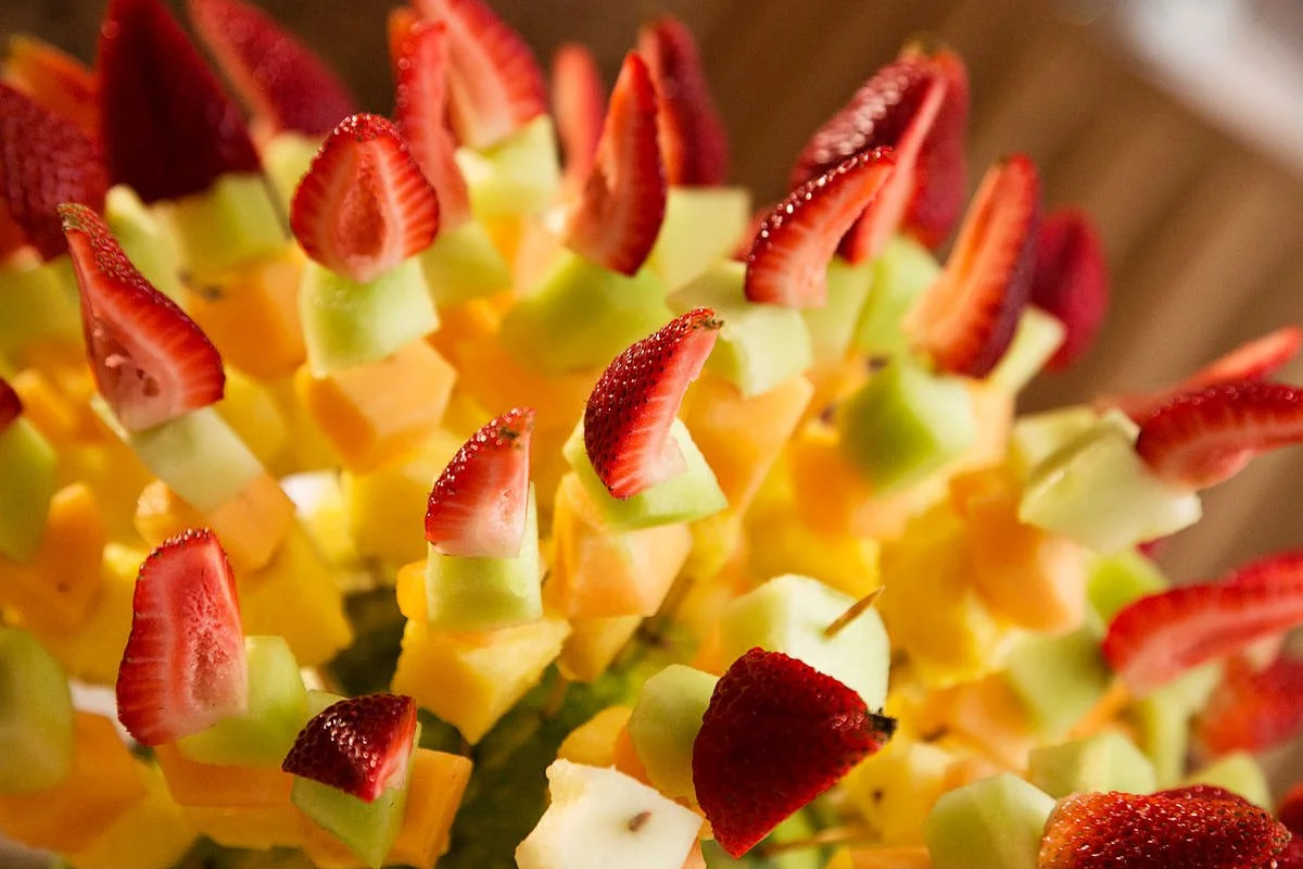 Chopped fruit on sticks.