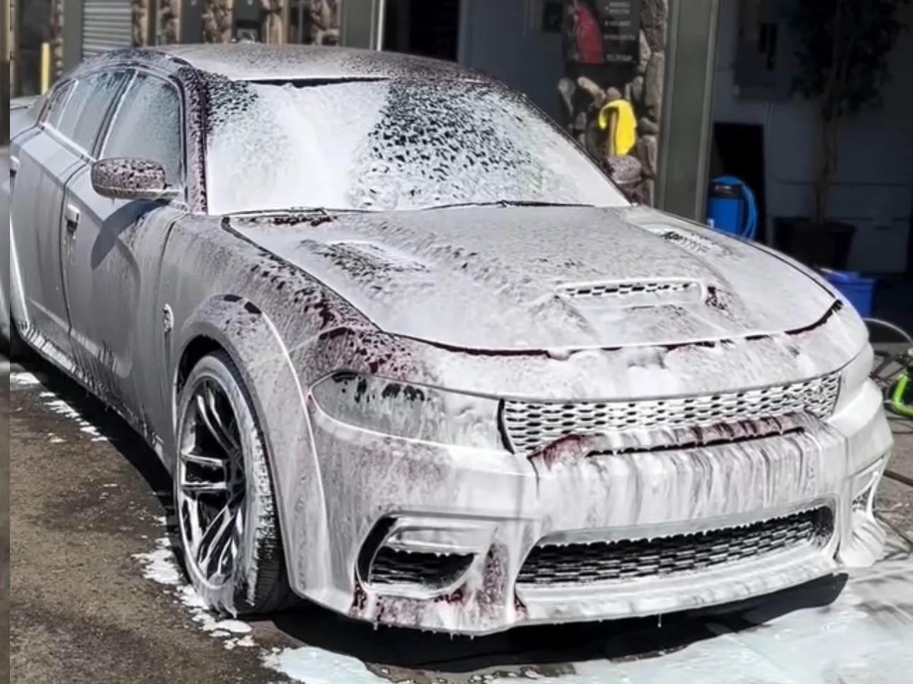 Luxury sedan SRT Dodge Charger covered in foam during professional hand wash before ceramic coating in Dublin CA
